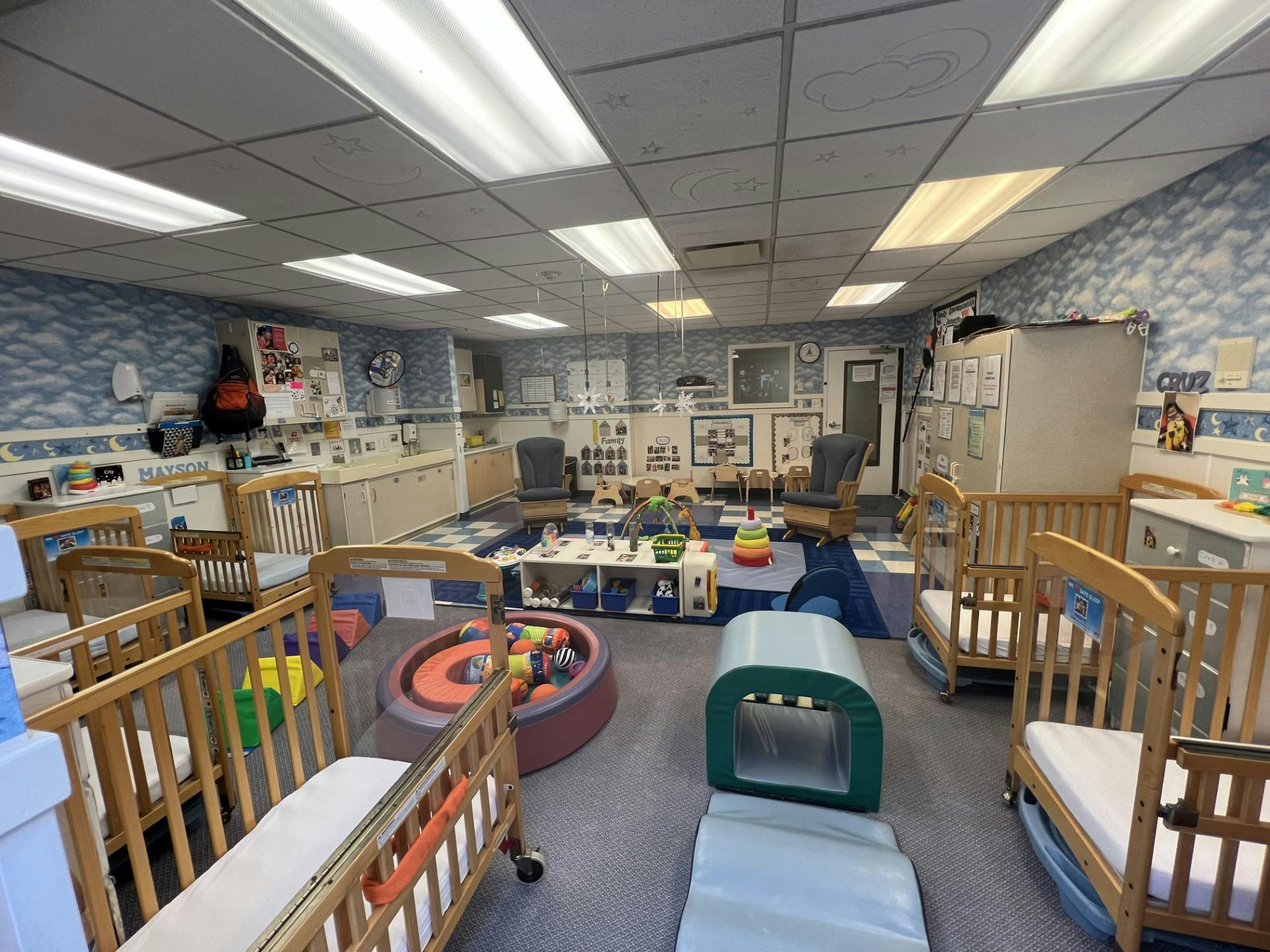Cribs and play area in a daycare classroom