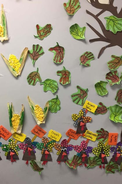 Children's artwork of turkeys, corn, and leaves on a wall
