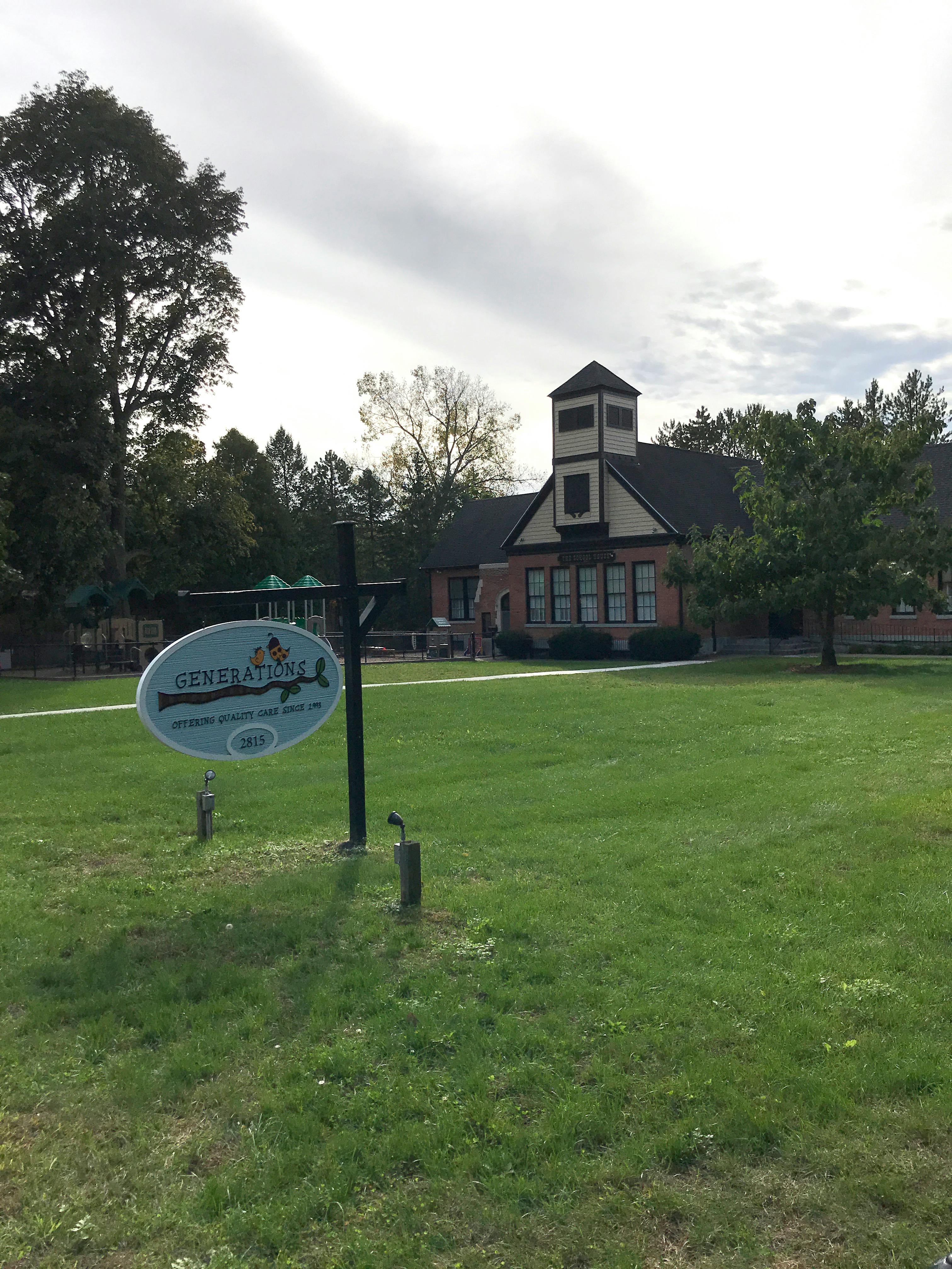 Sign for Geneva Children's Center in front of a building with a tower