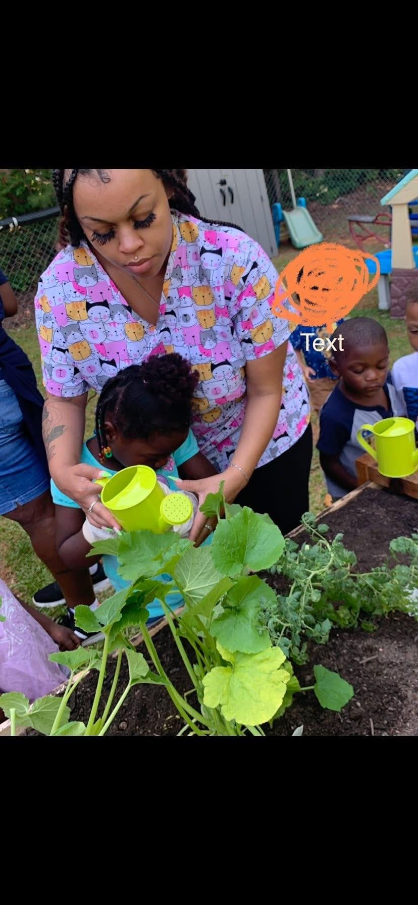 Person helping a child water plants in a raised garden bed with a watering can