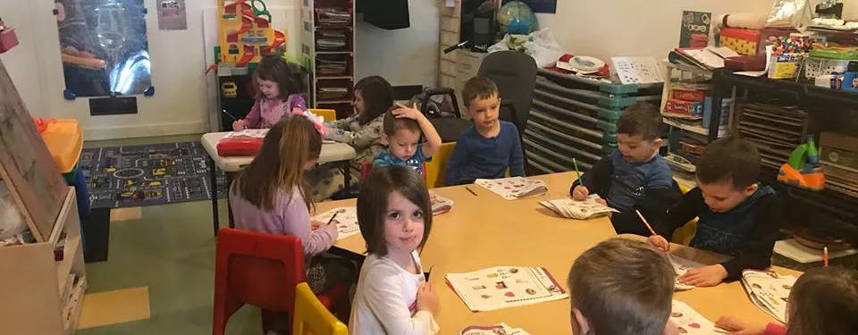 Children sitting at tables in a classroom
