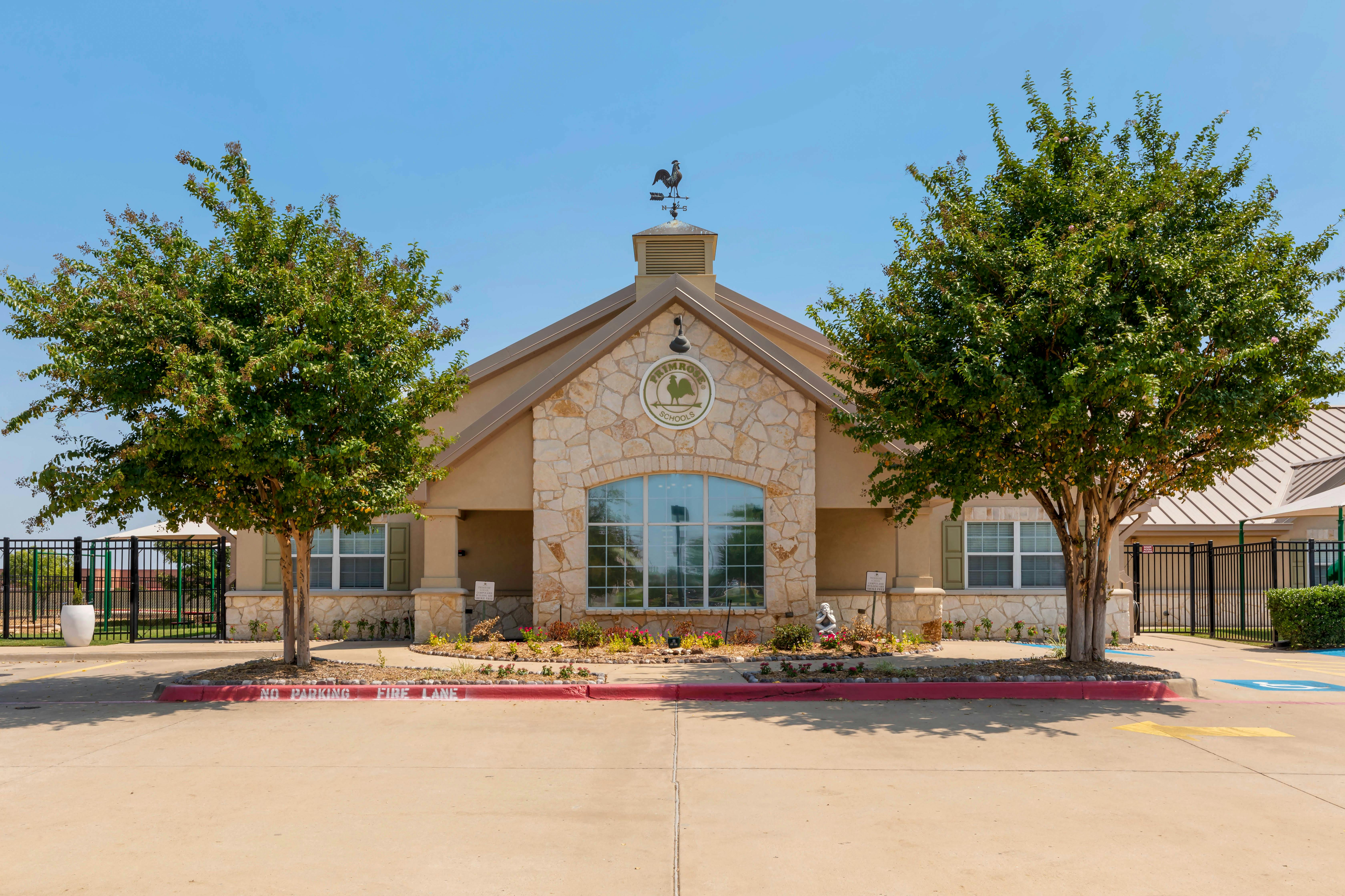A tan stone building with a sign that says PRIMROSE SCHOOLS