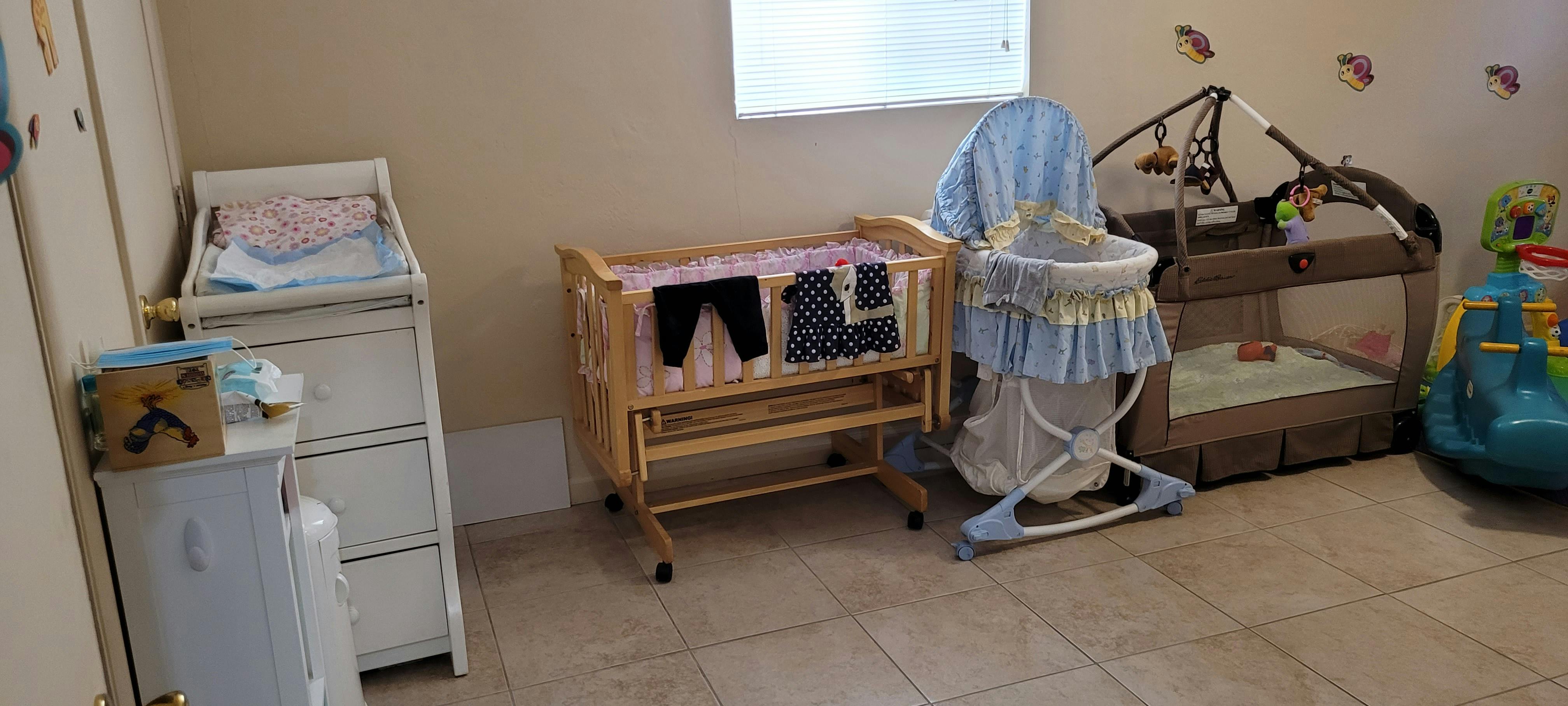 Nursery room with a changing table, bassinet, and playpen