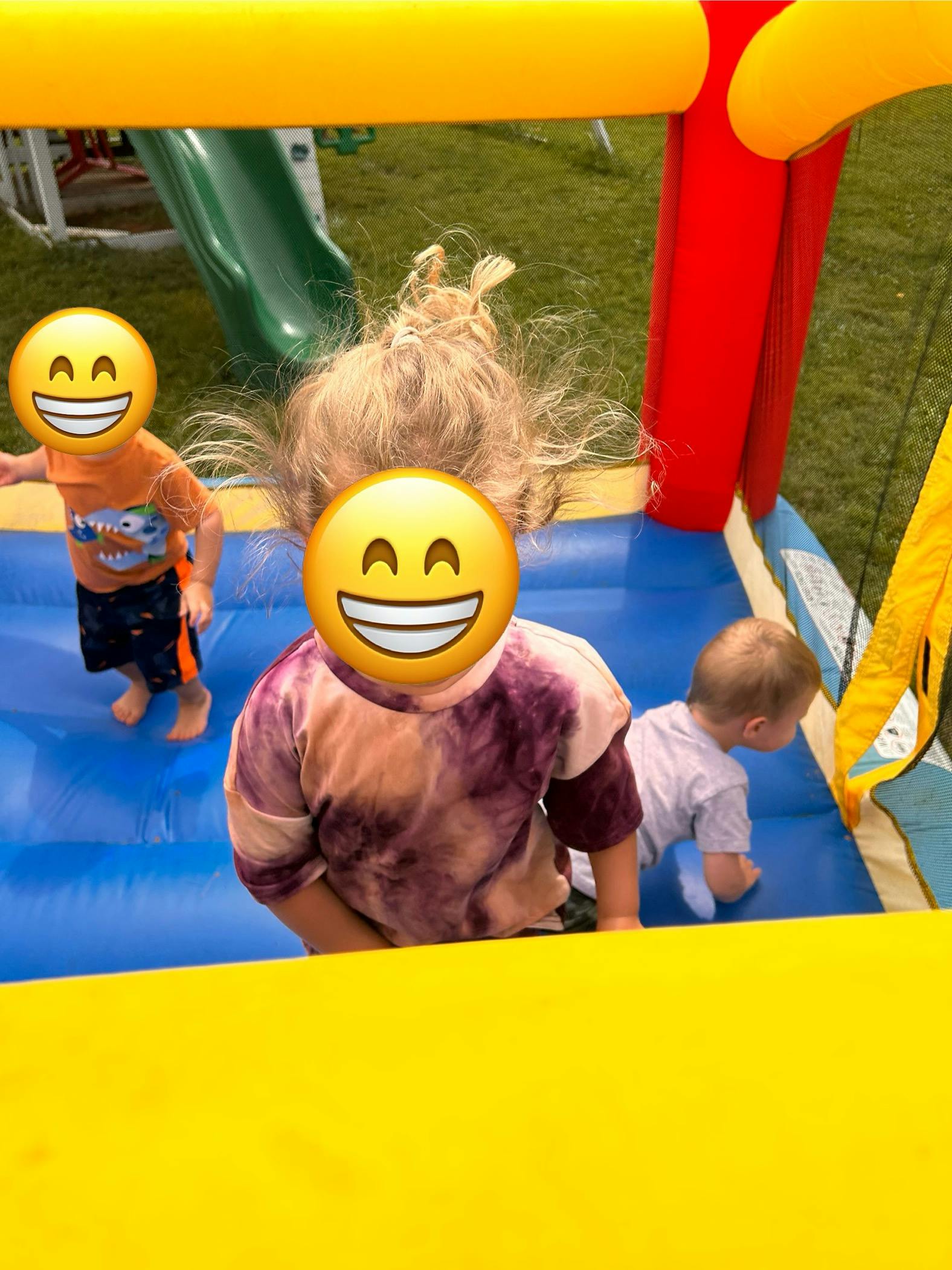 Three children playing in a bounce house