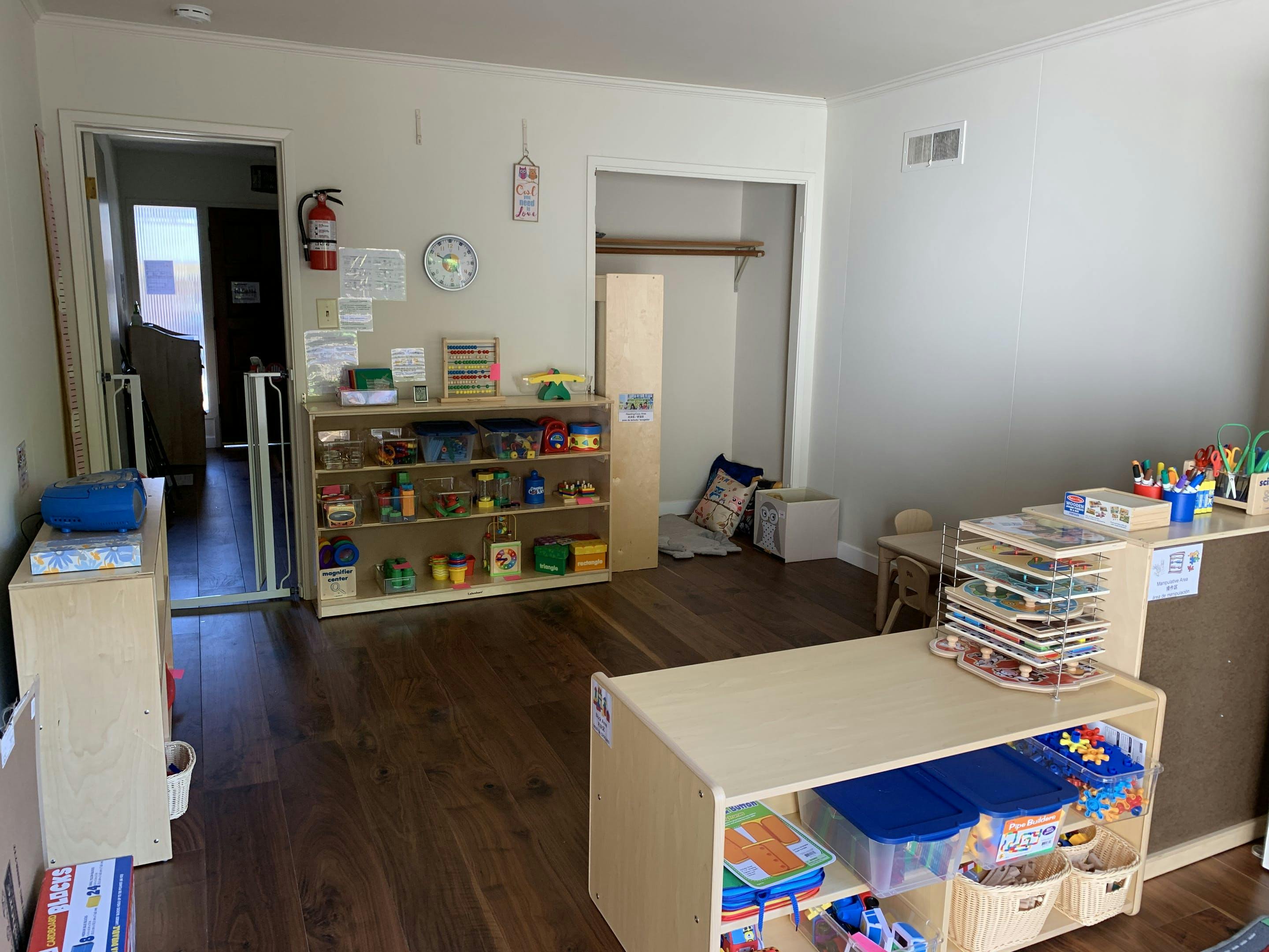 Classroom with wooden shelves filled with toys and learning materials