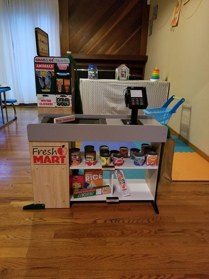 Toy Fresh Mart stand with various play food items and a cash register