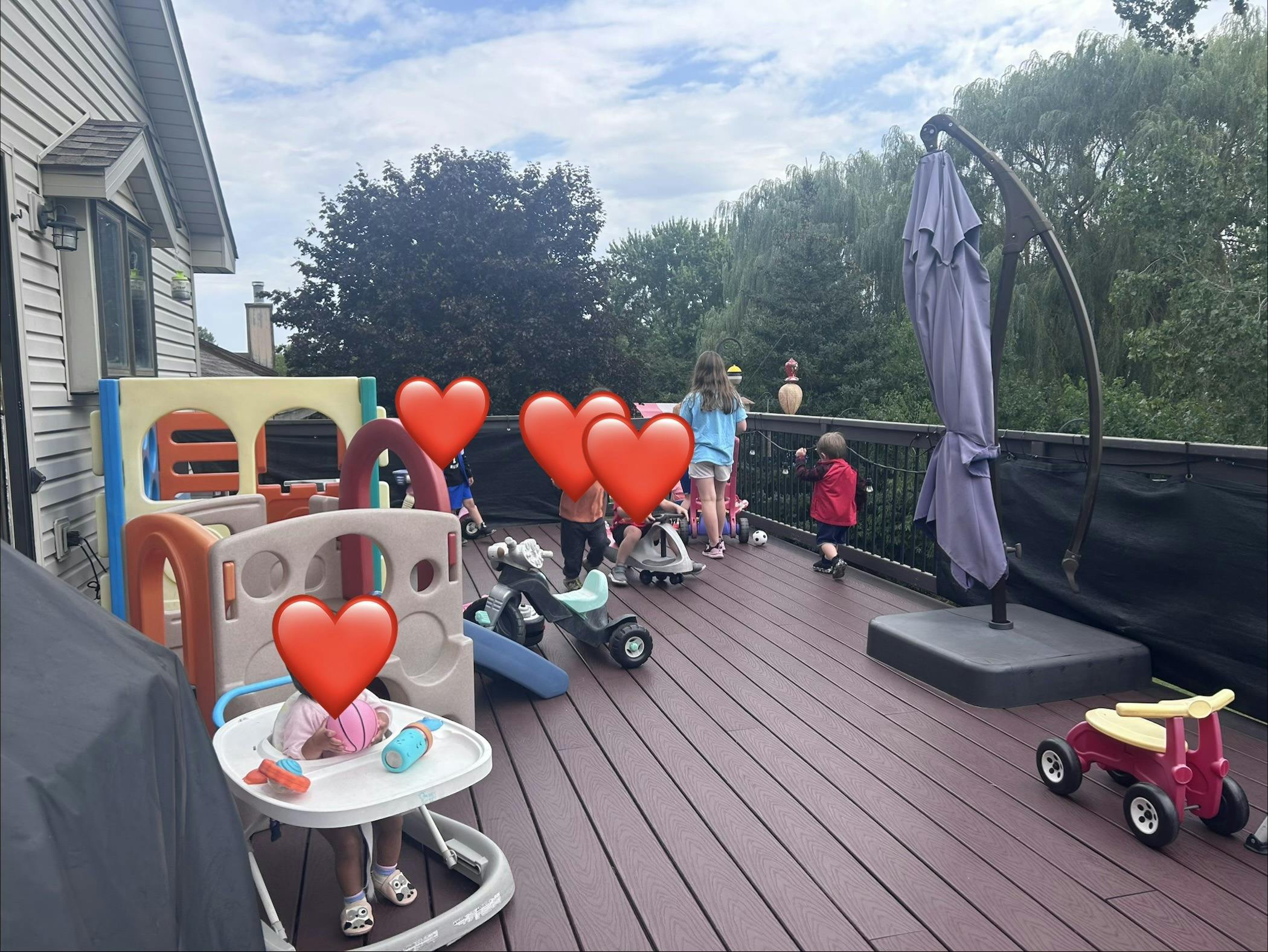 Children playing with ride-on toys on a residential deck