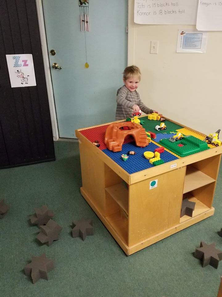 Child playing with toys on a play table