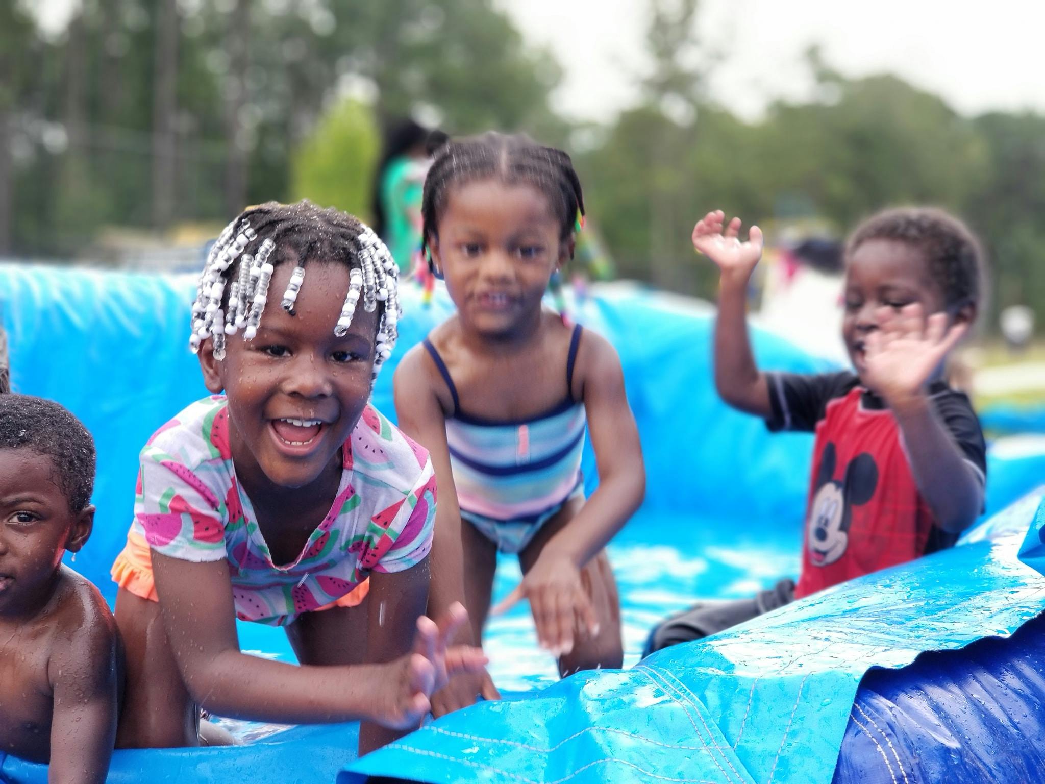 Children playing in a blue inflatable pool