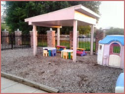 Outdoor play area with a covered structure and small tables