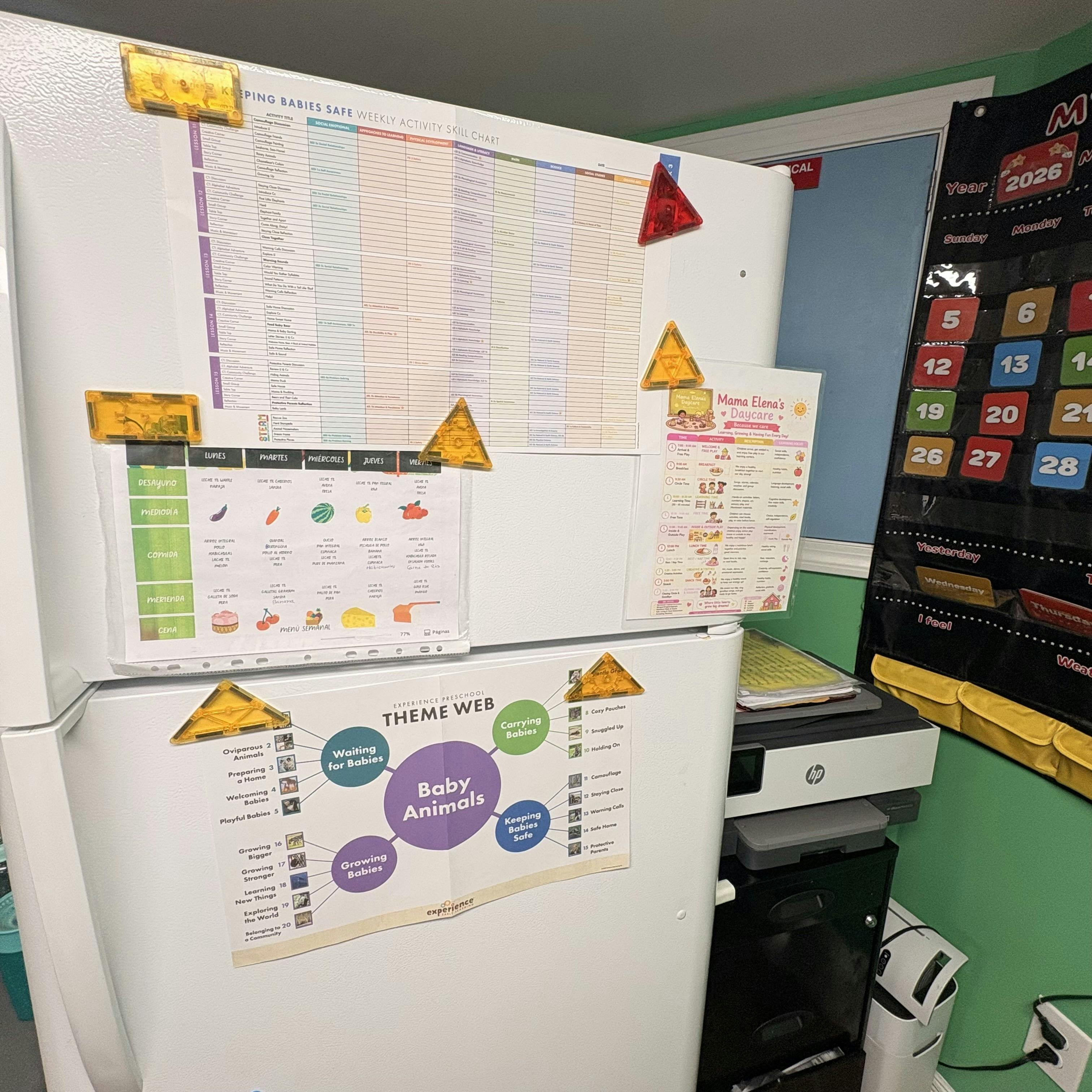 Refrigerator covered with charts and papers, including a weekly activity chart