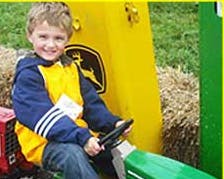 Child sitting on a toy tractor