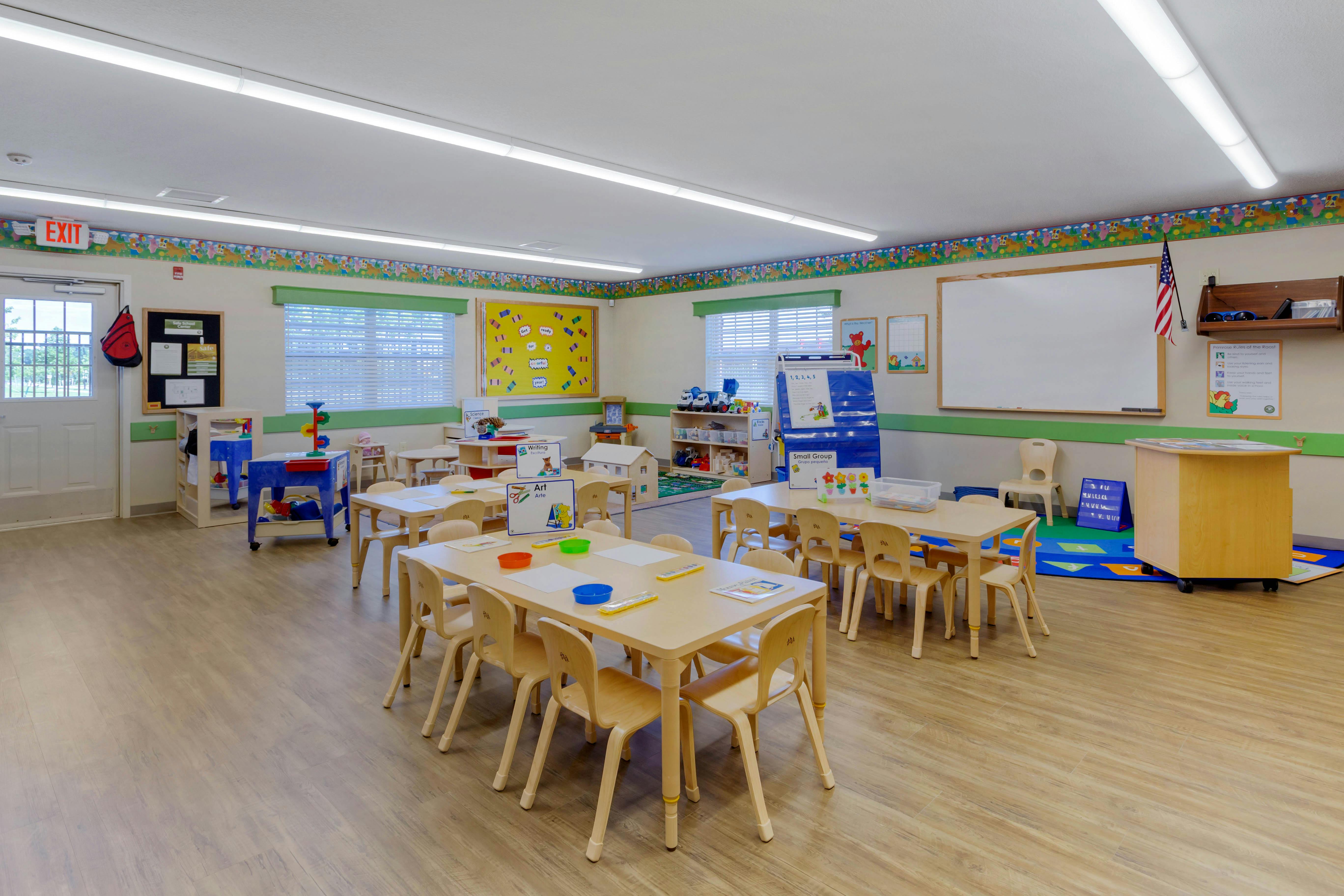 Classroom with child-sized tables and chairs, toys, and learning materials