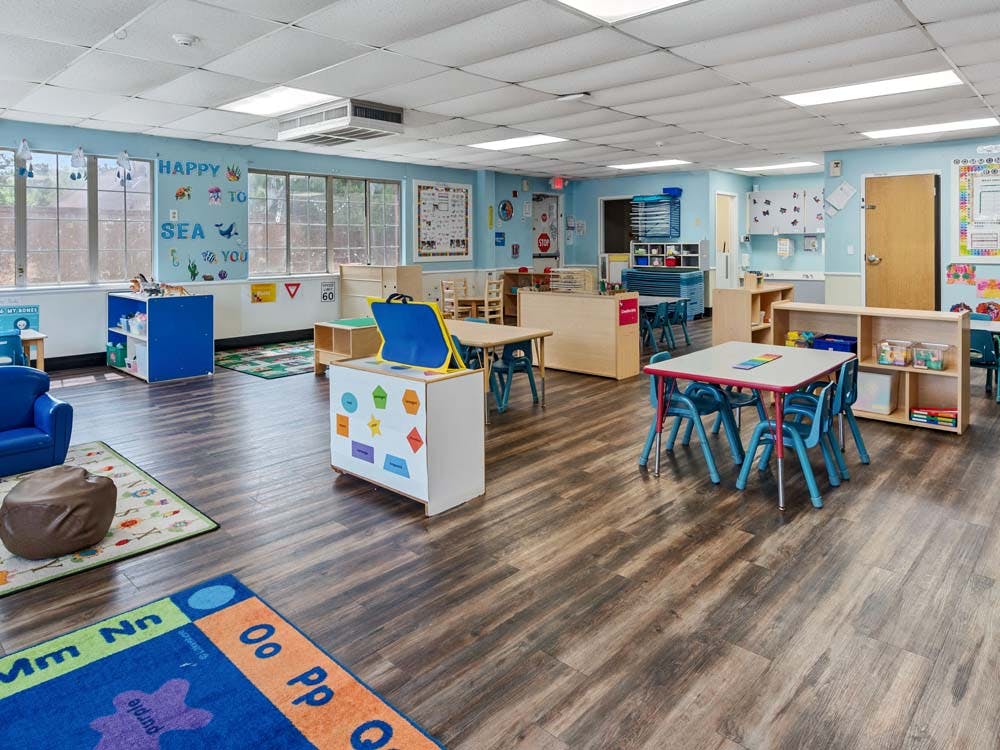 empty preschool classroom with small tables and chairs