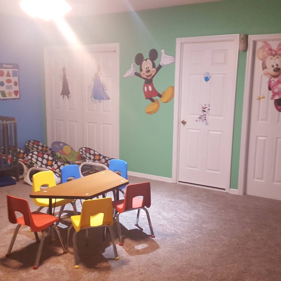 Children's table and chairs in a room with cartoon wall decals