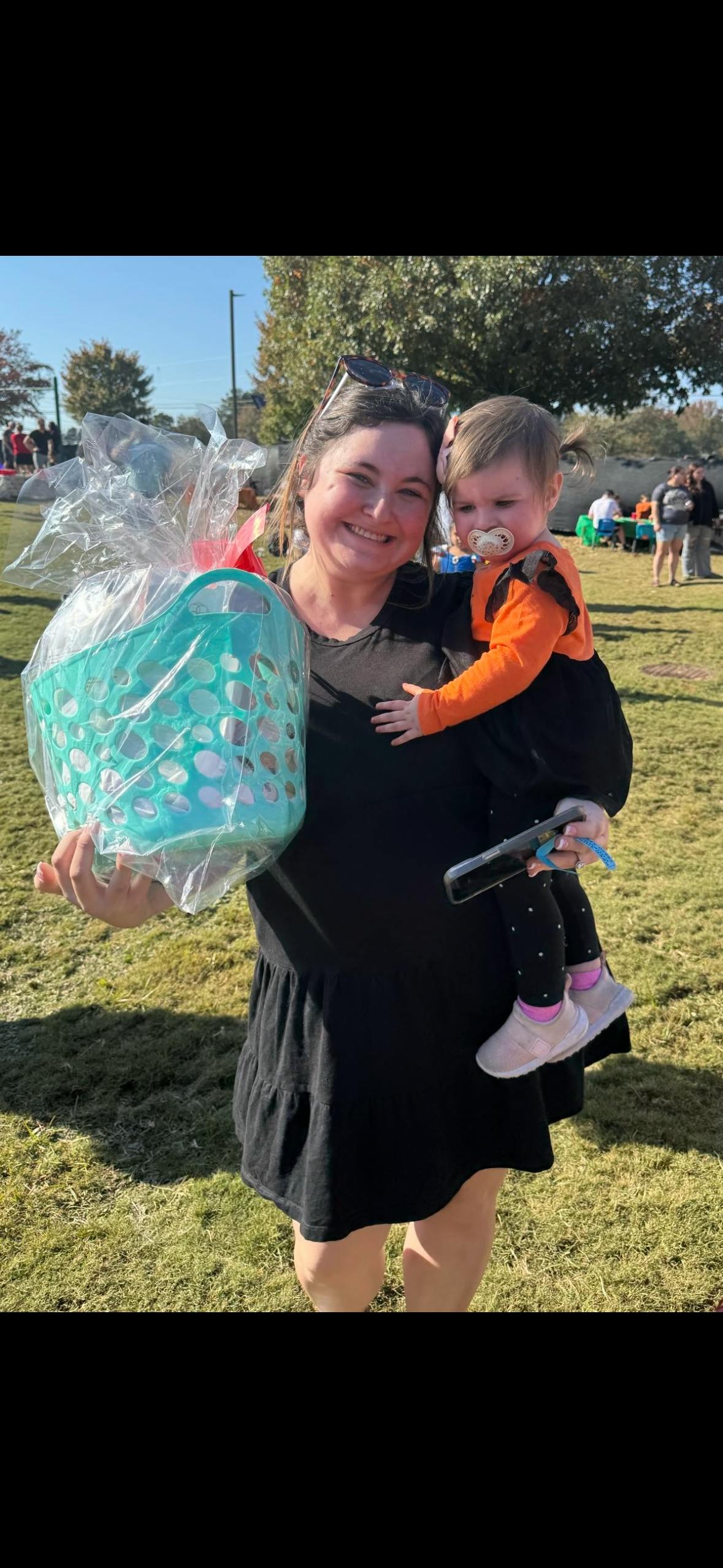 Person holding a basket and a child with a pacifier