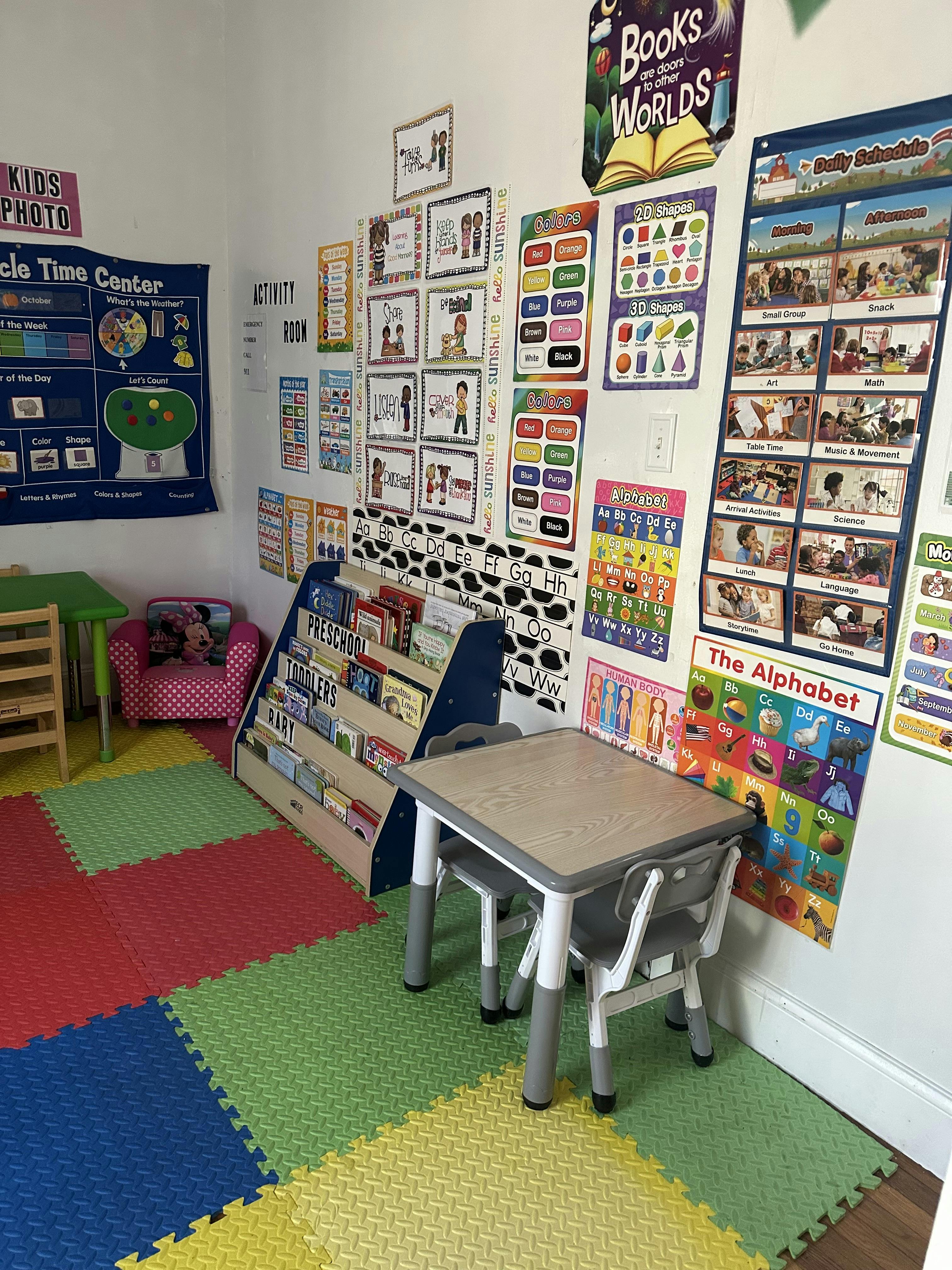 Classroom with colorful floor mats, small tables, and educational posters on the walls