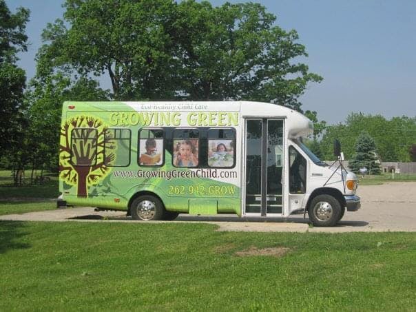 White and green bus with "Growing Green" text and images of children