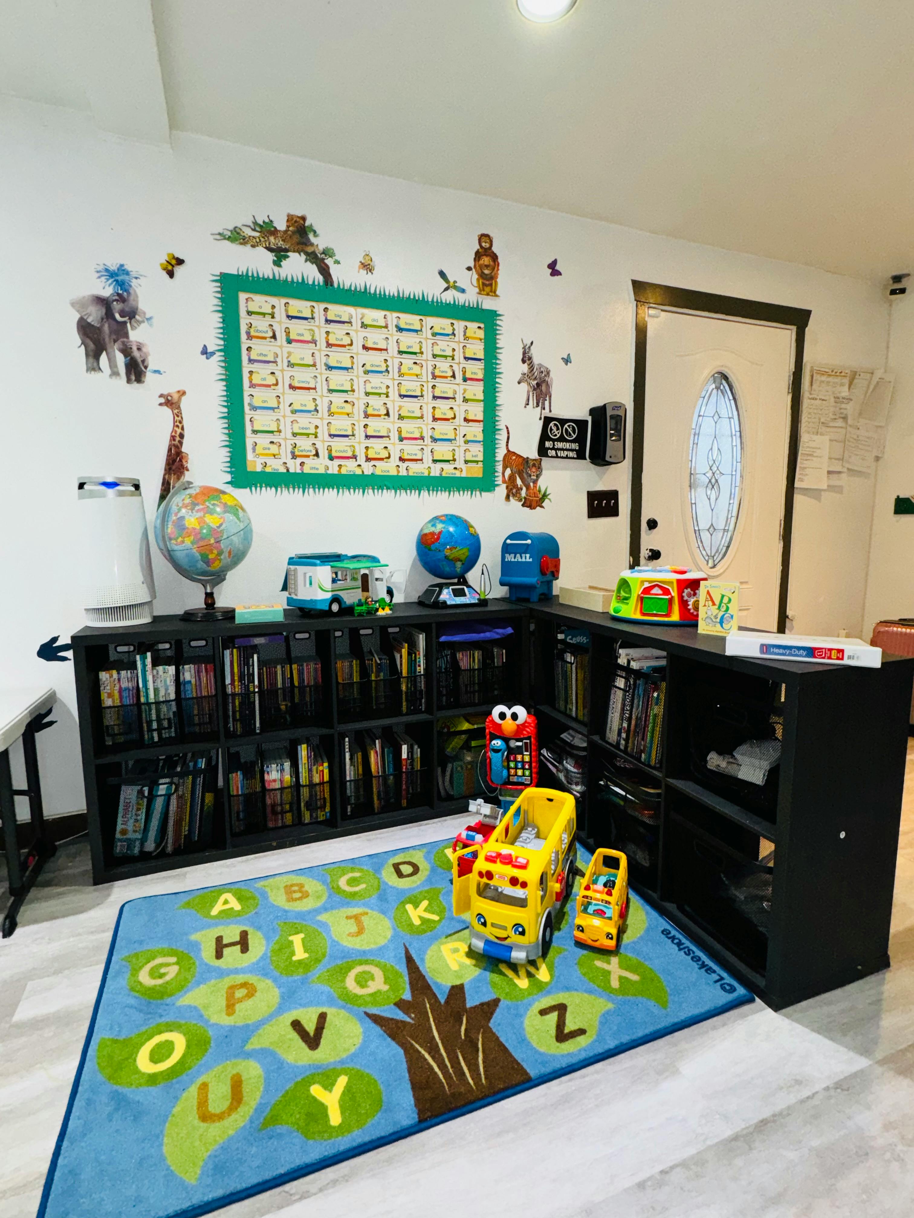 Children's playroom with alphabet rug, bookshelves, and wall decorations