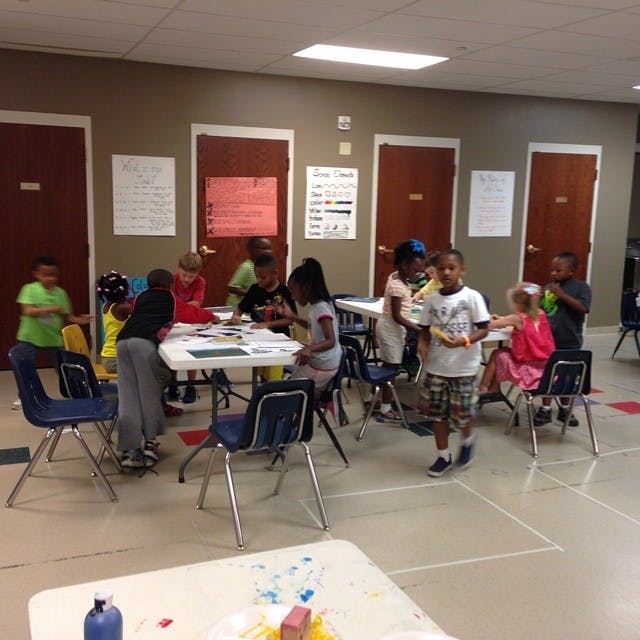 Children gathered around tables in a classroom