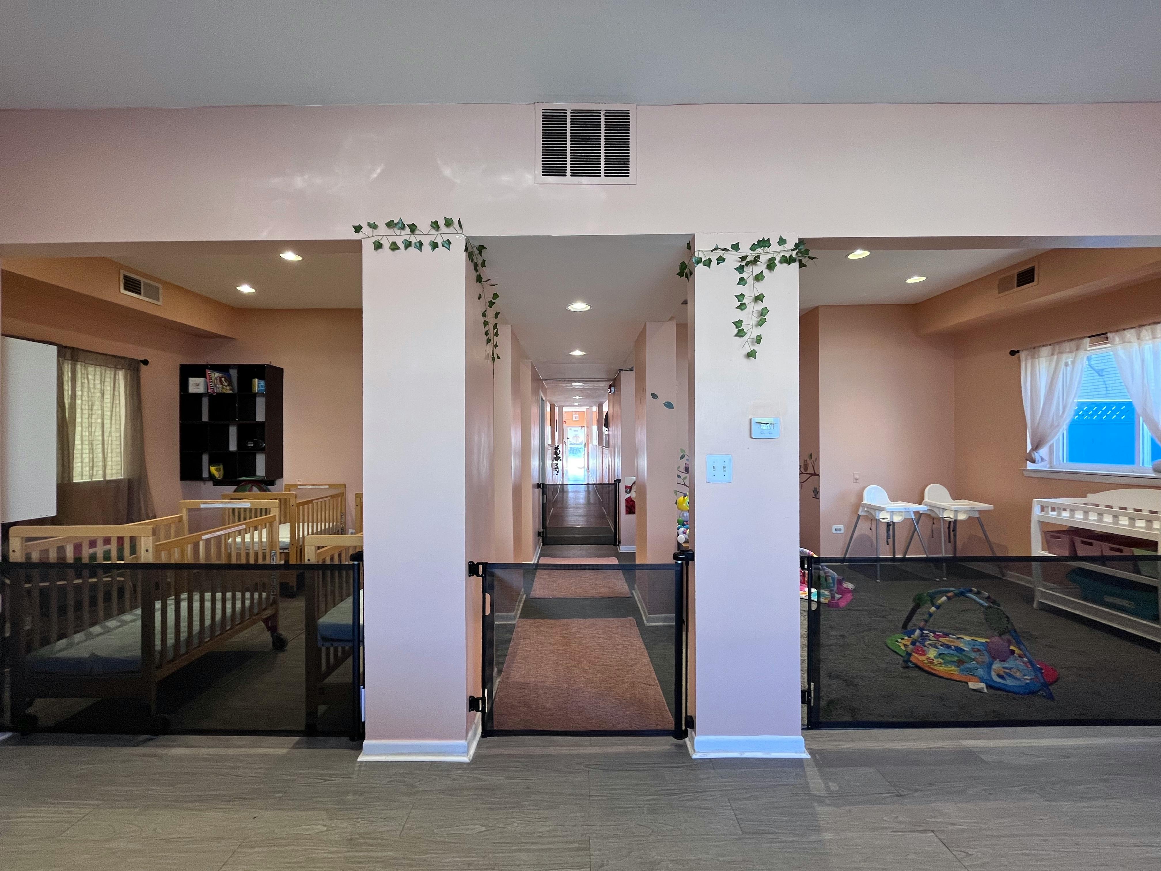 Nursery room with multiple cribs and baby gates