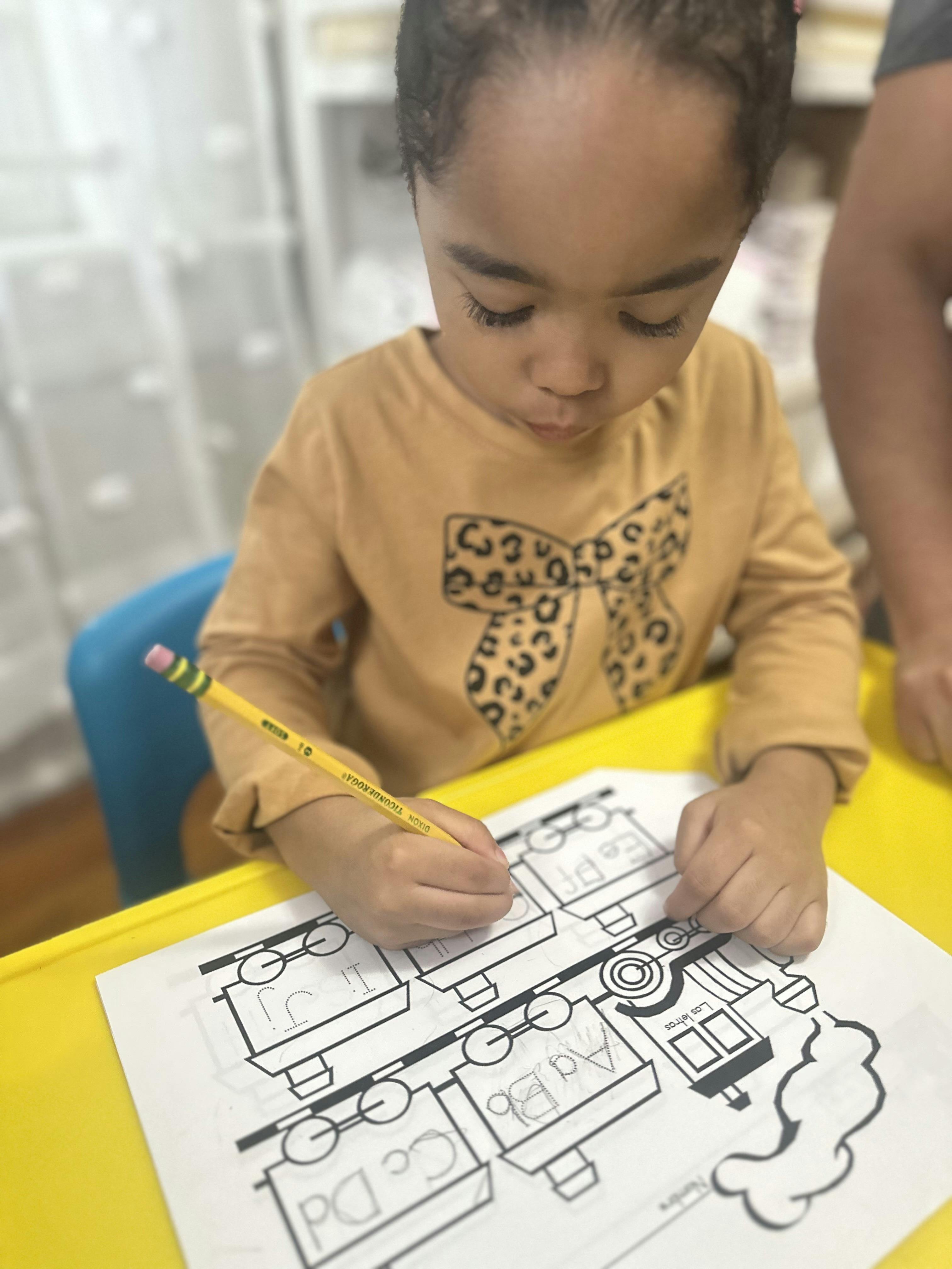 Child drawing on a paper with a pencil