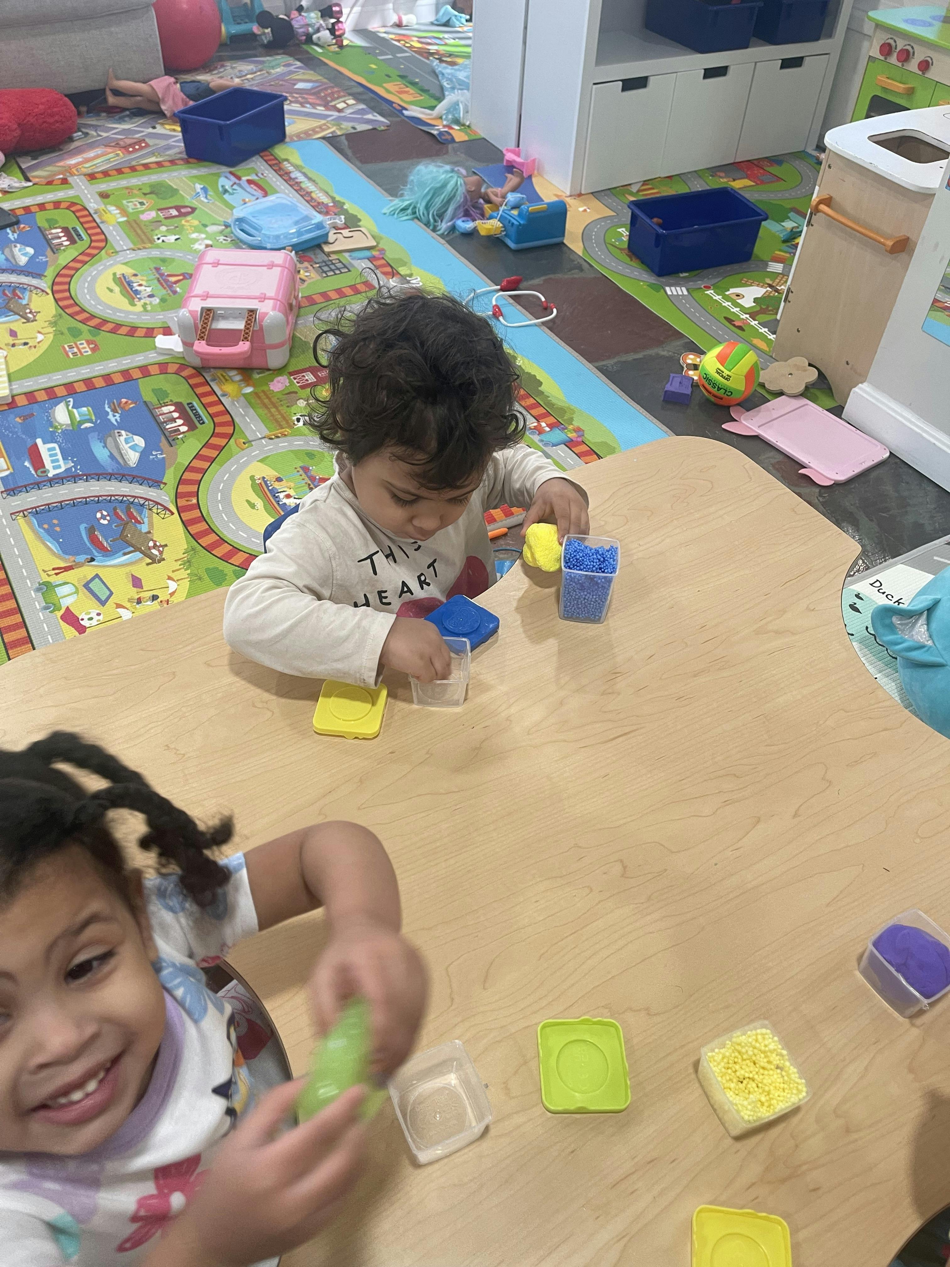 Two children playing with colorful blocks and containers at a table