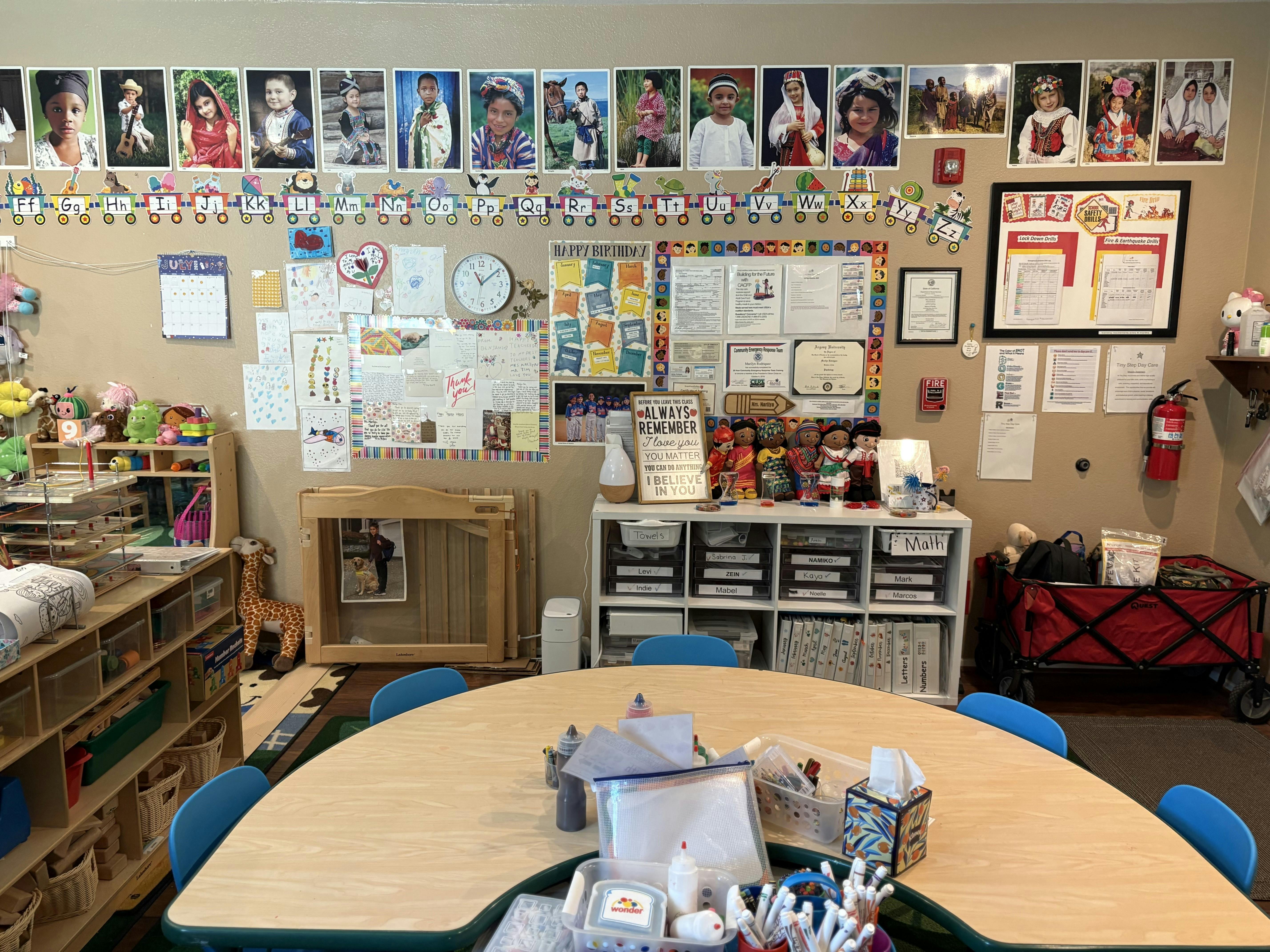 Classroom with a curved table and children's artwork on the wall