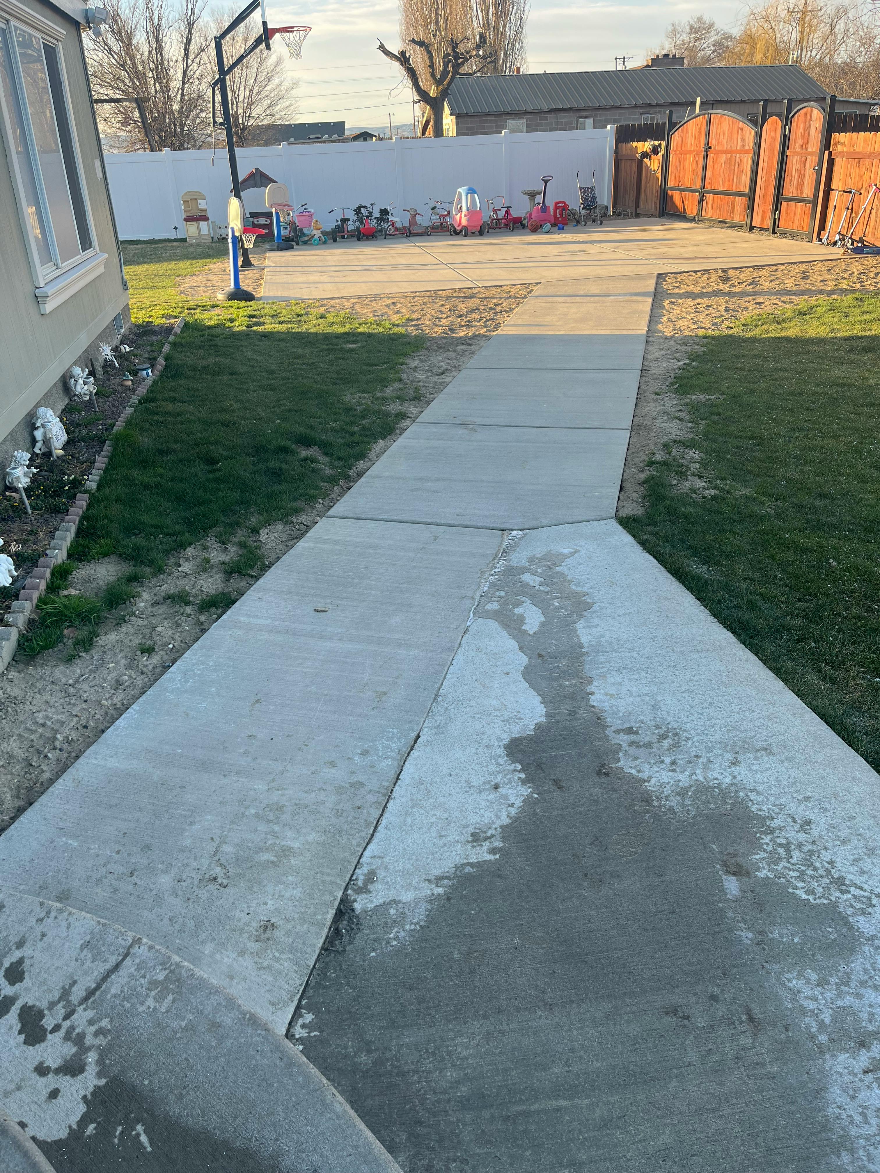 Concrete sidewalk and driveway with grass on either side
