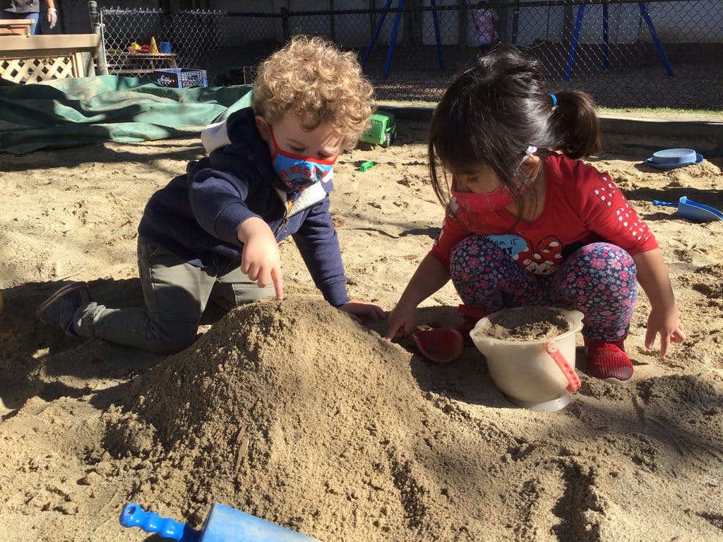 Two children playing in a sandbox