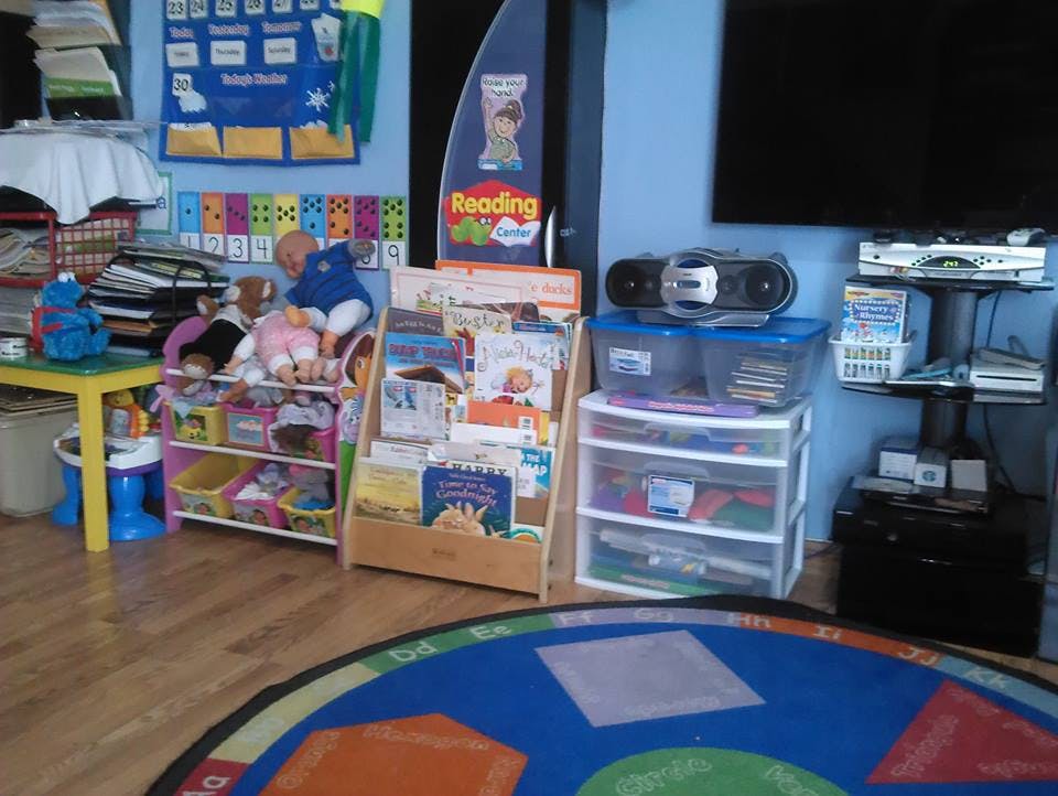 Childcare room with toys, books, and a blue rug