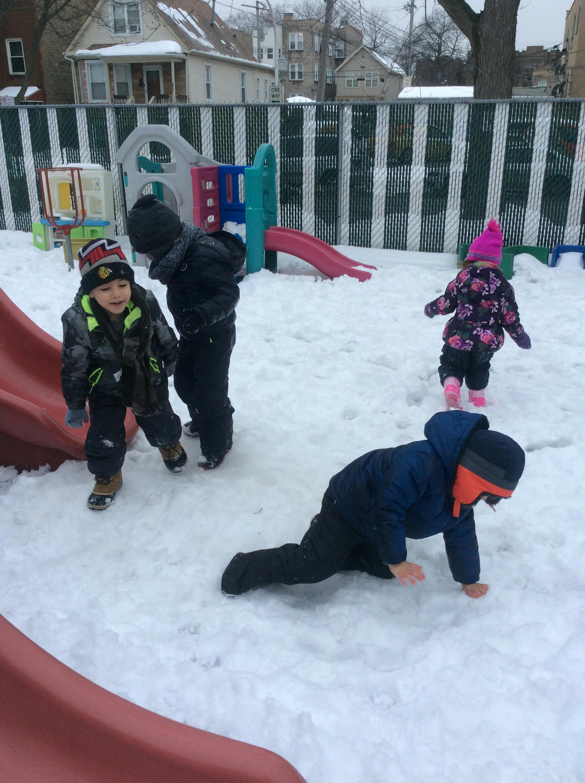 Children playing in snow on a playground