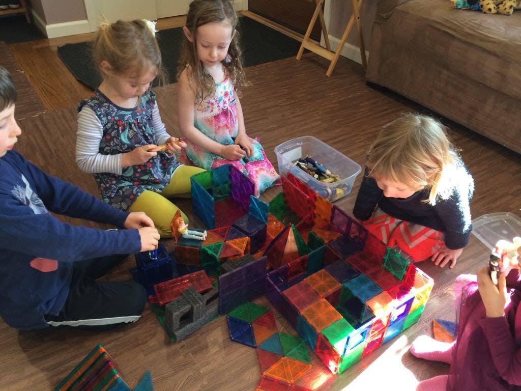 Children playing with colorful magnetic building blocks on the floor