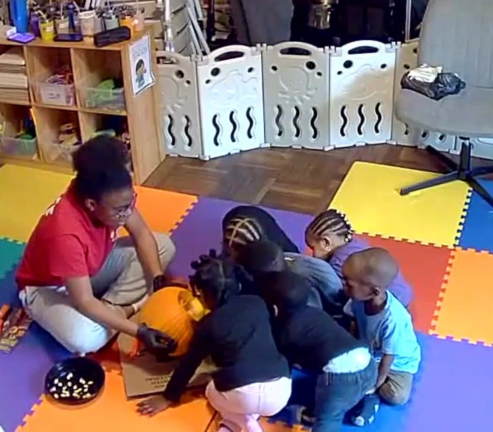 Person and children carving a pumpkin