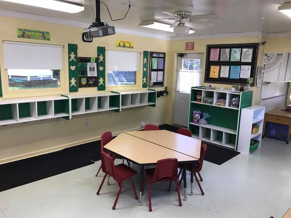 Classroom with hexagonal table and chairs, storage cubbies, and windows