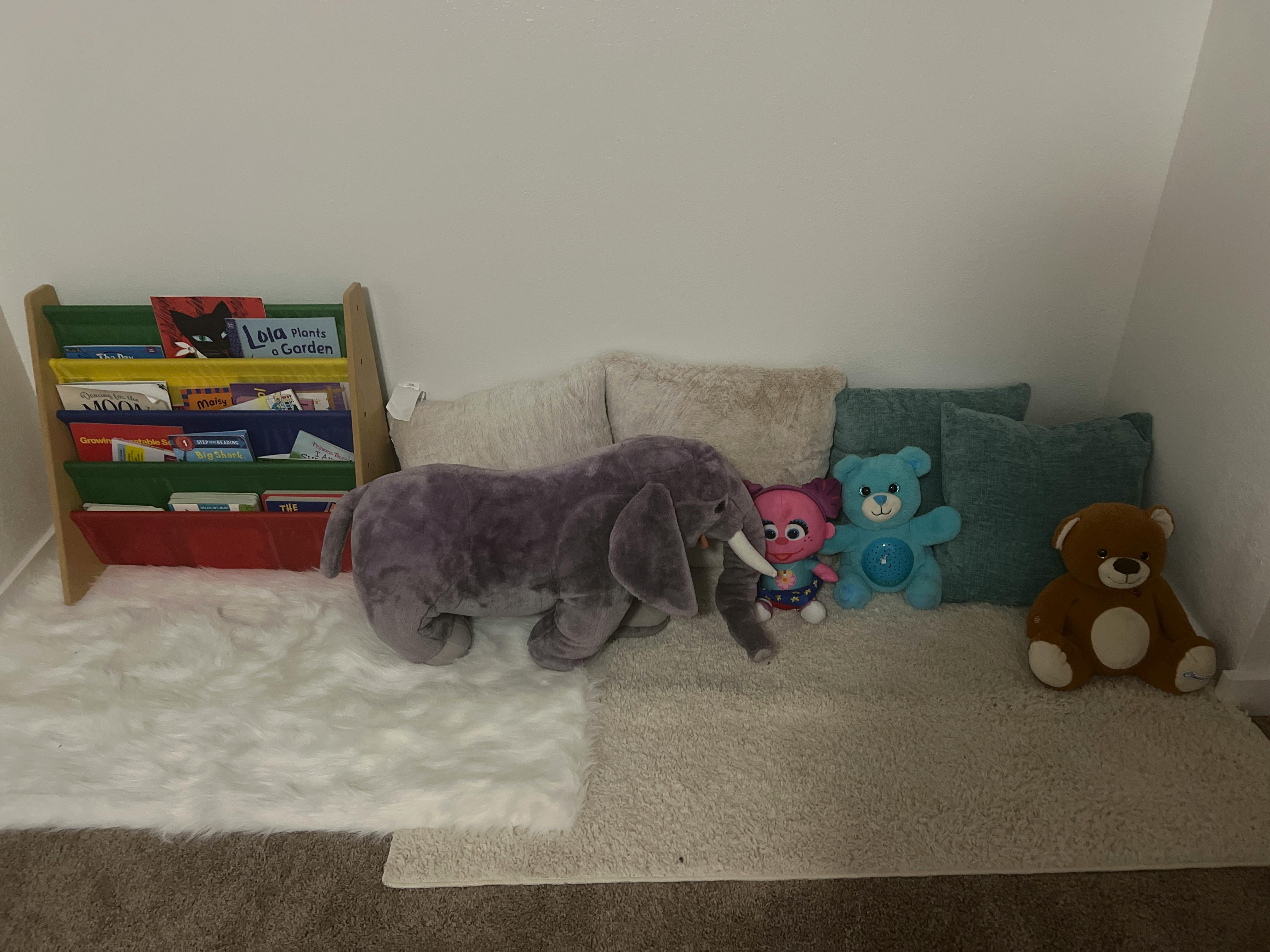 Stuffed elephant, teddy bears, and a bookshelf with books