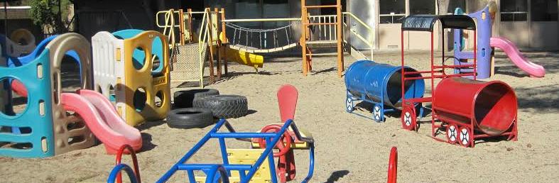 Playground with slides, climbing structures, and train-shaped tunnels