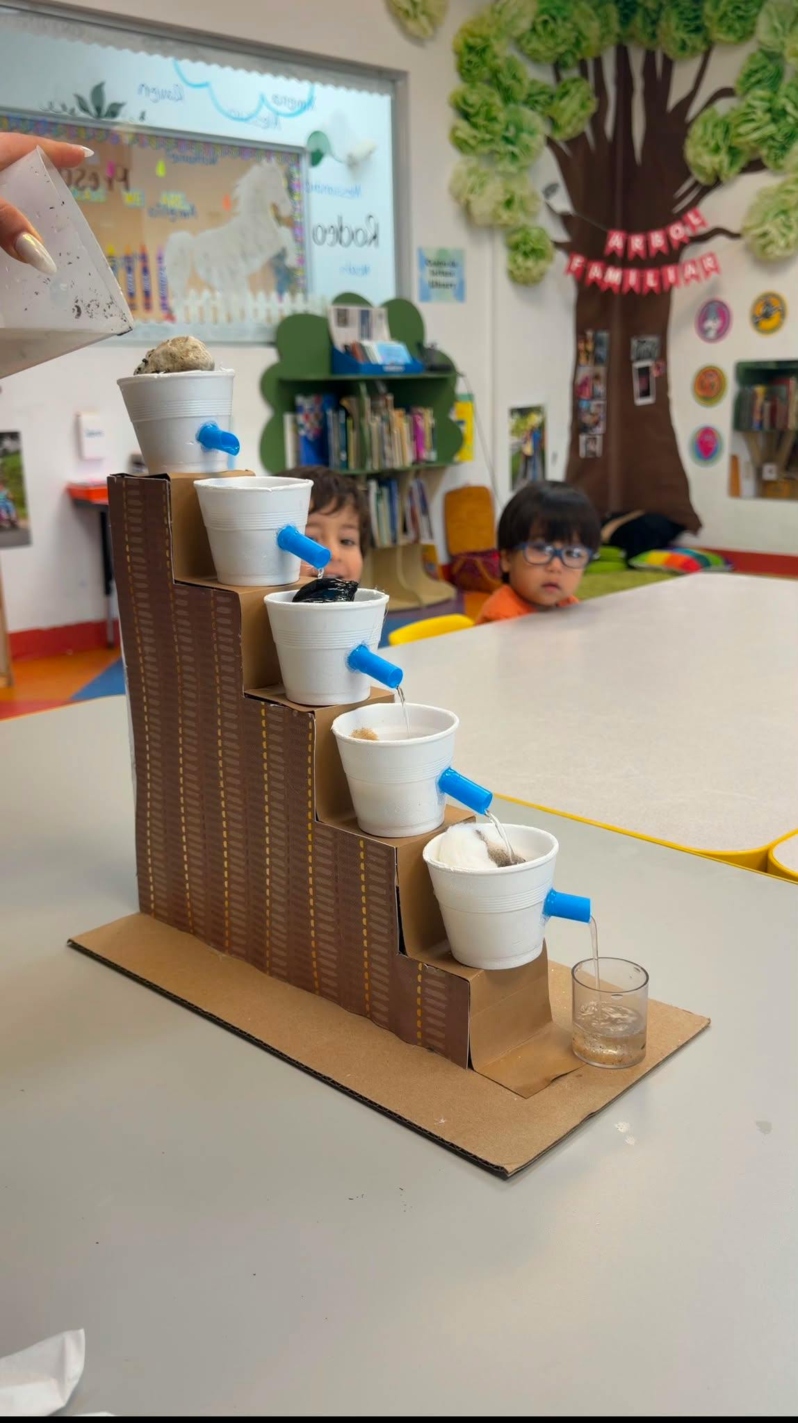 Water cascading through a stepped cardboard and plastic cup science experiment