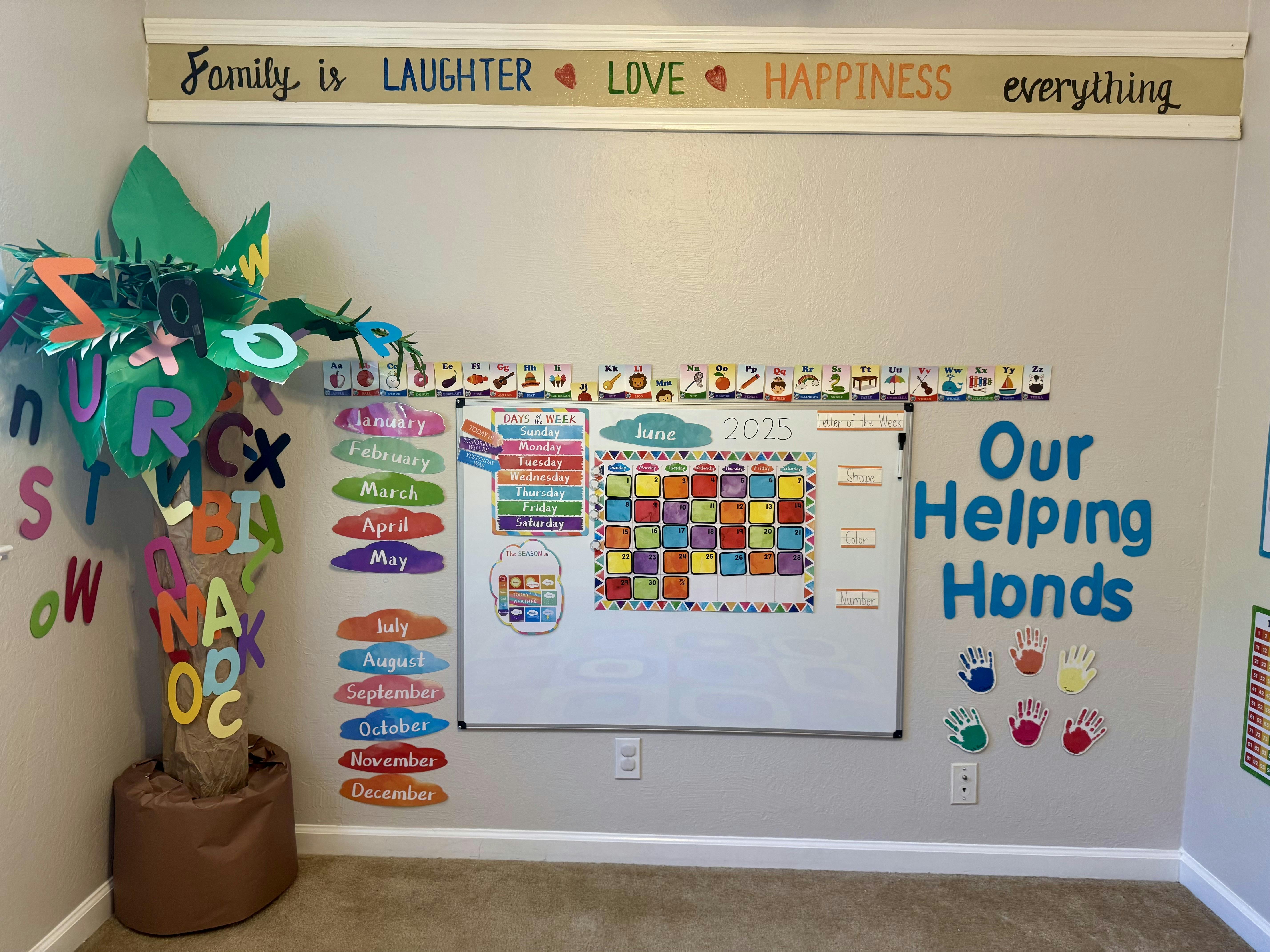 Classroom wall with a whiteboard, calendar, and decorative palm tree with letters