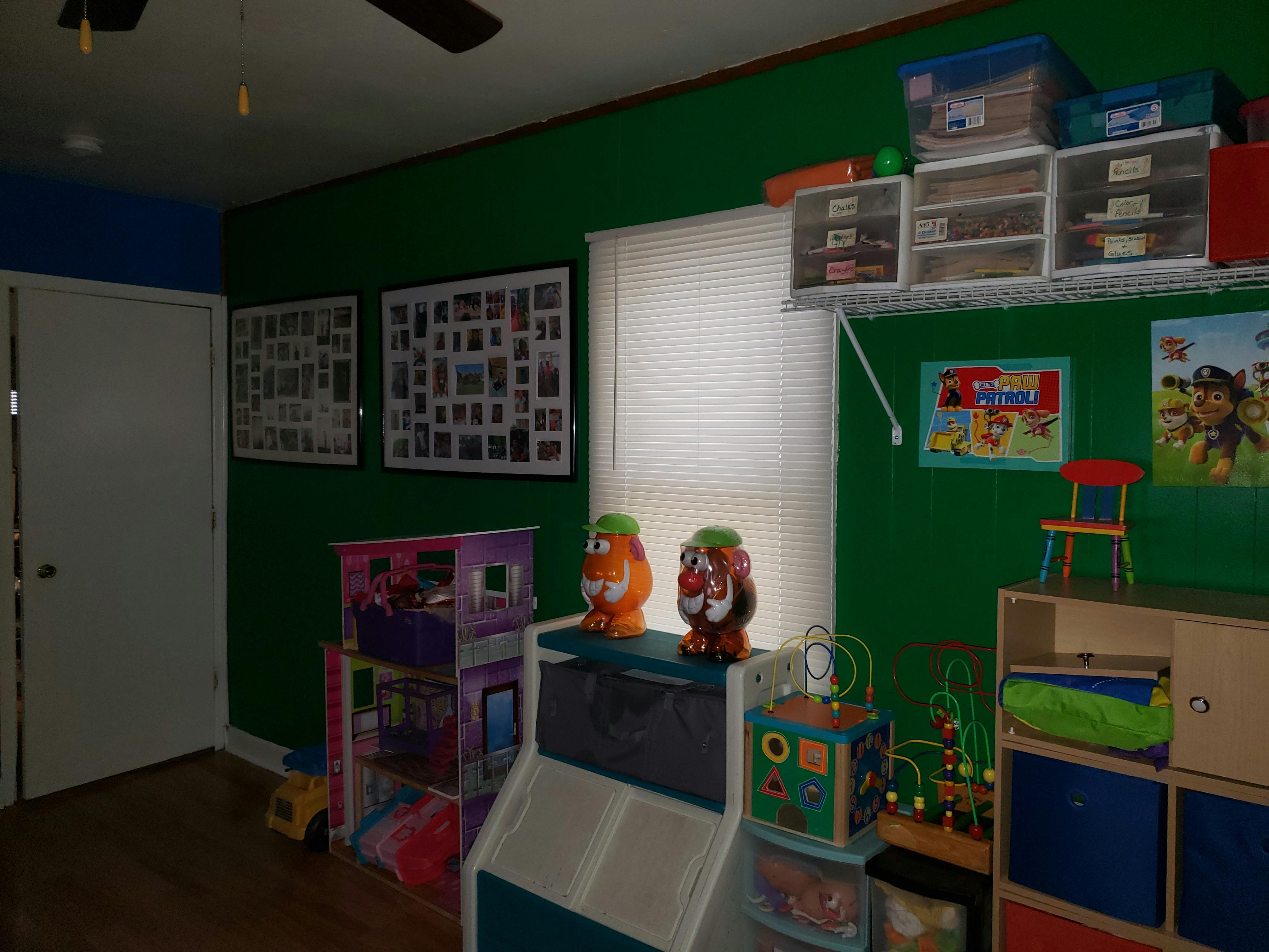 Playroom with green walls, toys, and storage shelves