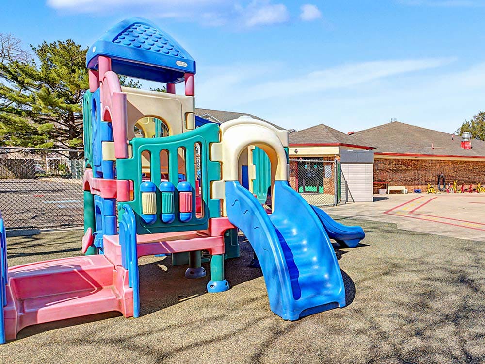 Colorful playground structure with slides and steps on an outdoor play area