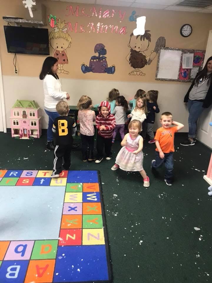 Adult and multiple children in a classroom