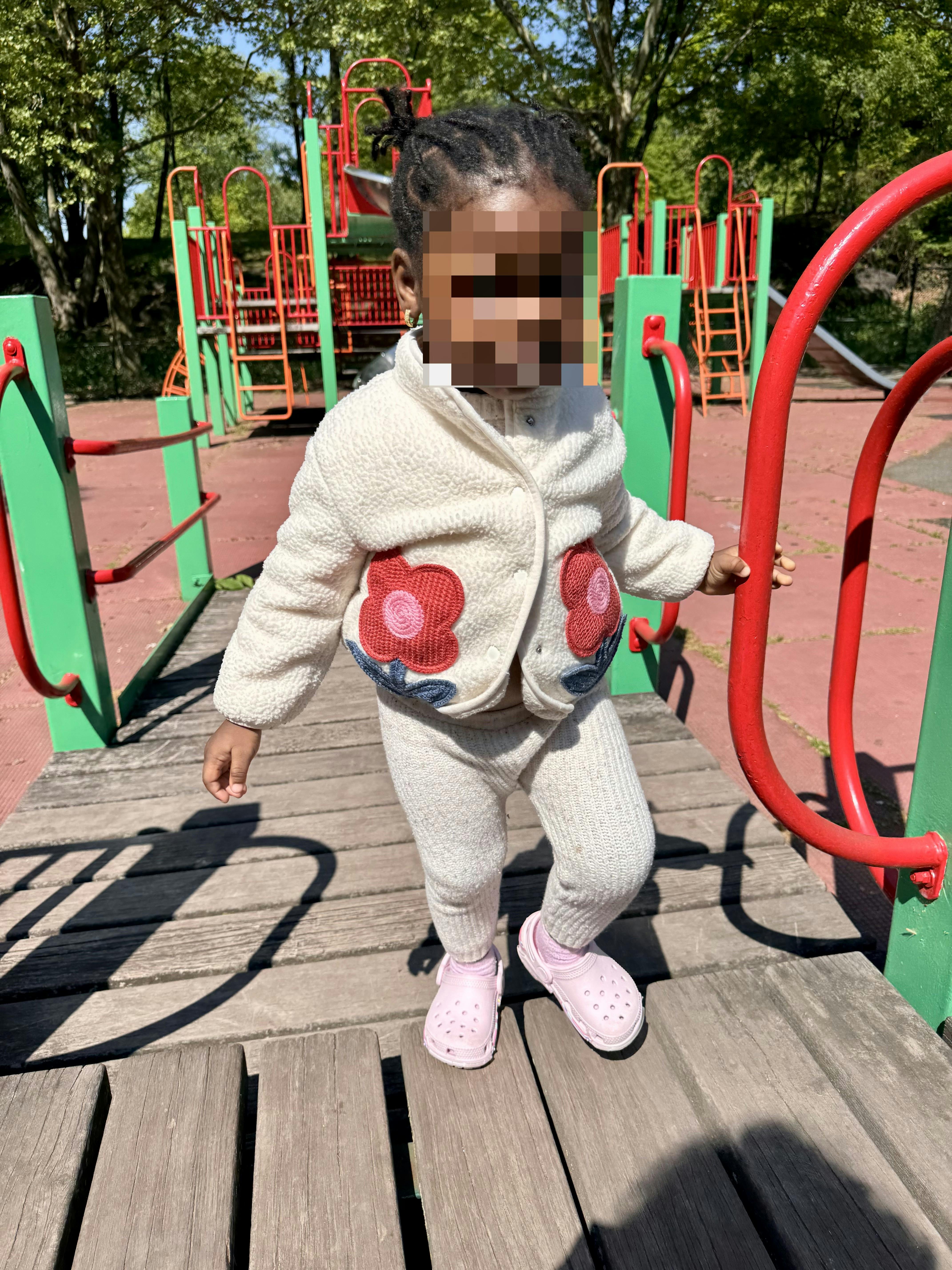 Child walking on a wooden bridge at a playground