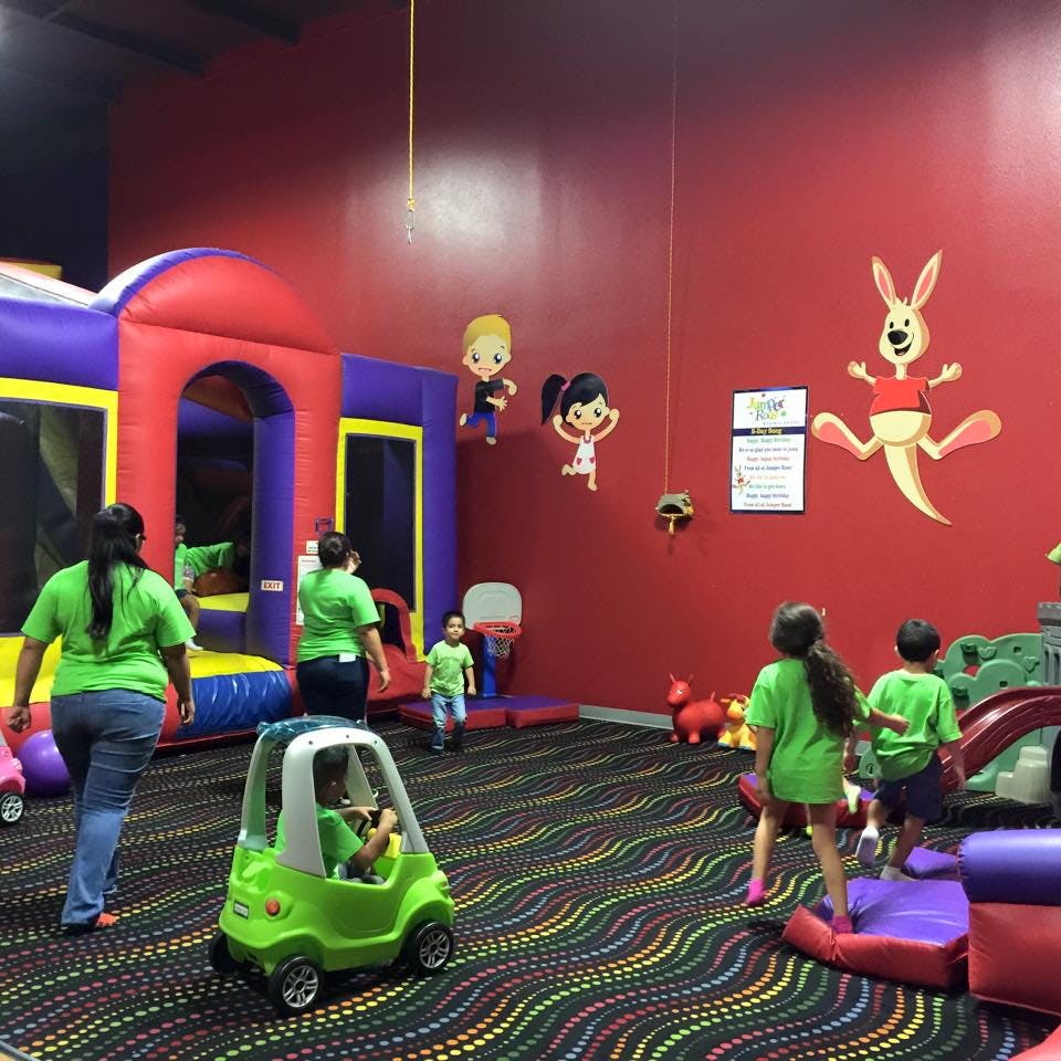 People and children playing in an indoor play area with inflatables