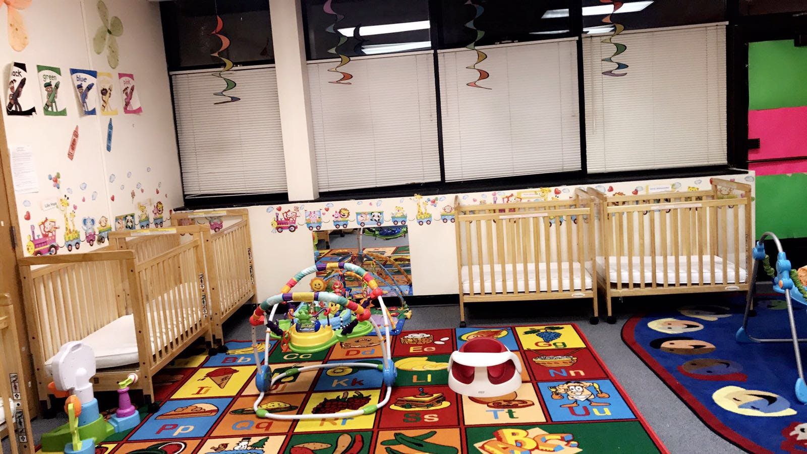 Nursery room with multiple cribs and colorful play mats