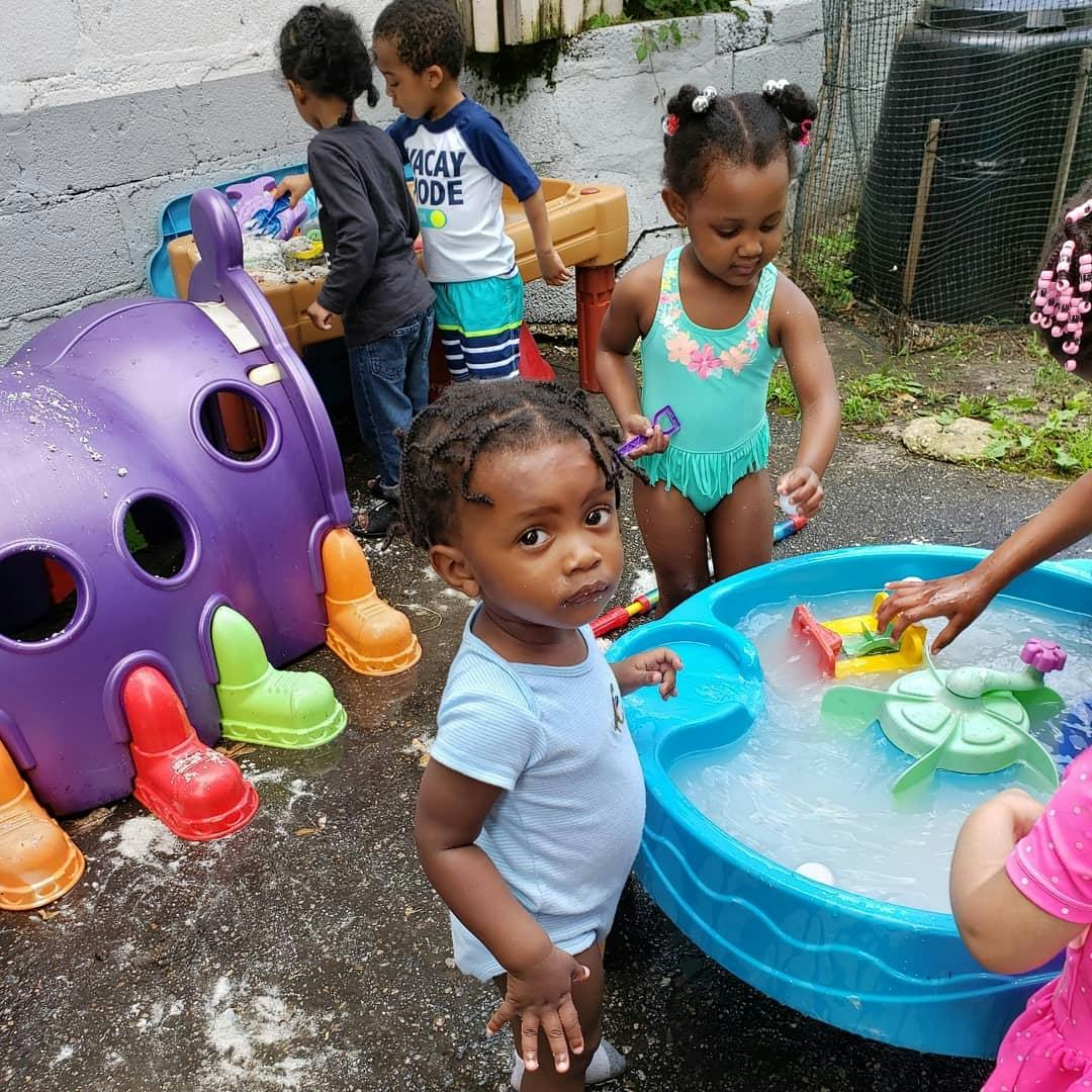 Children playing with water and toys outdoors