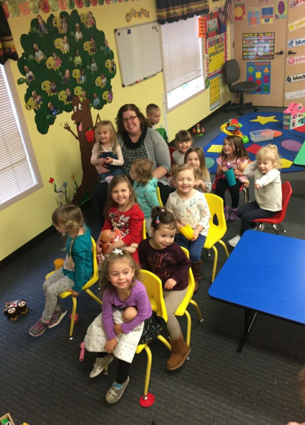 Adult and multiple children sitting in a classroom