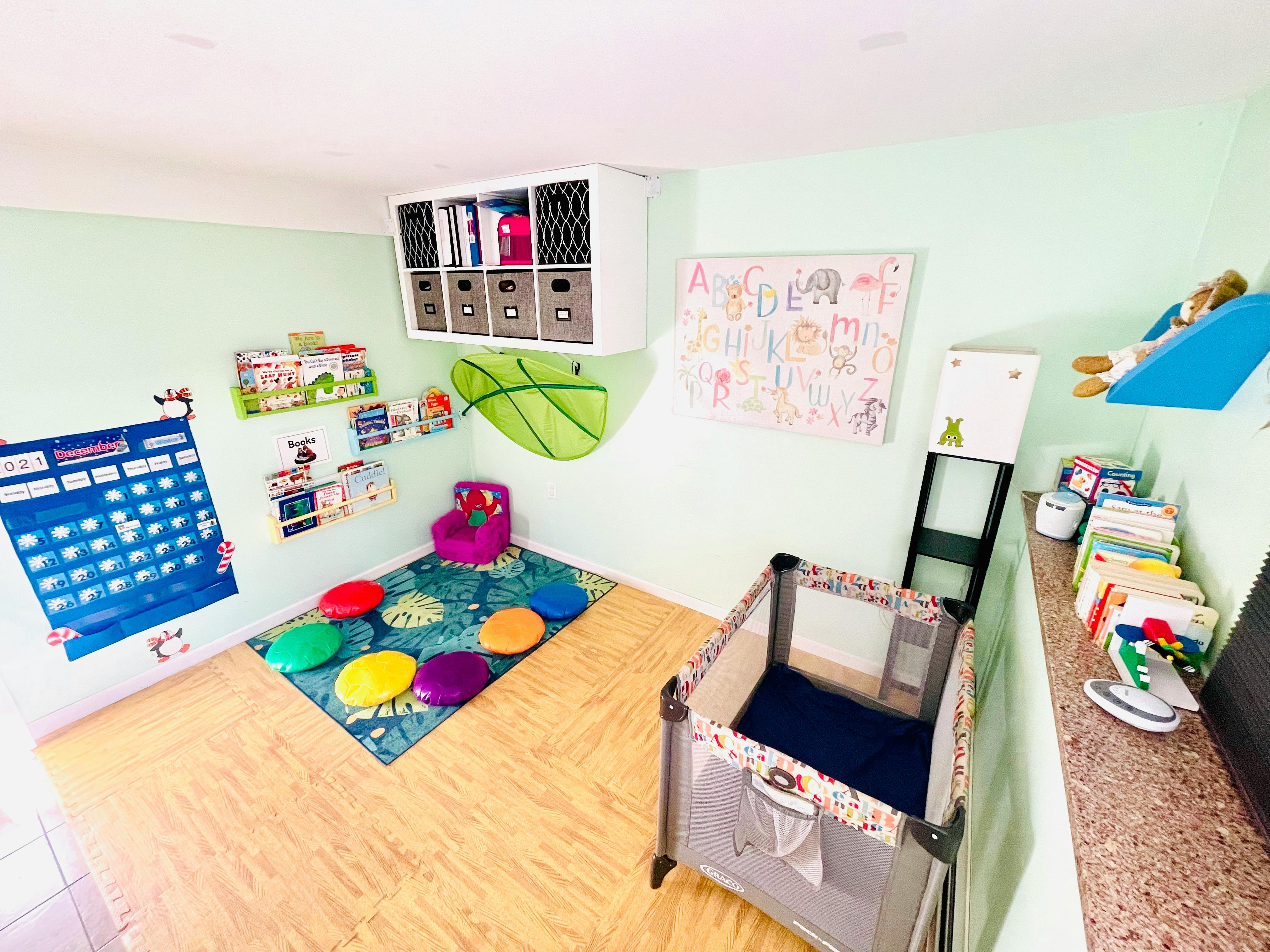 Playroom with a crib, colorful rug, and wall decorations