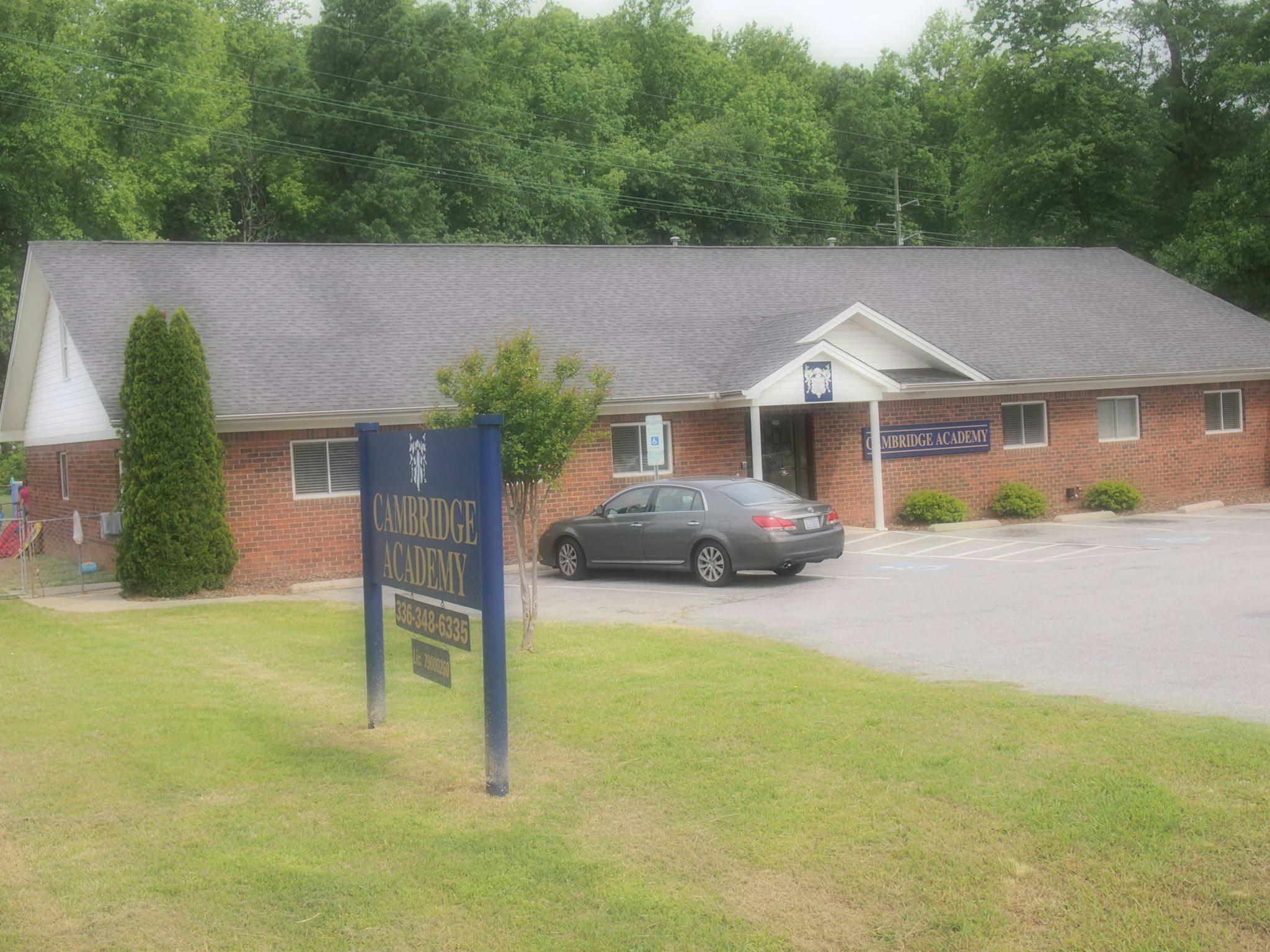 Brick building with a car parked in front and a sign in the foreground