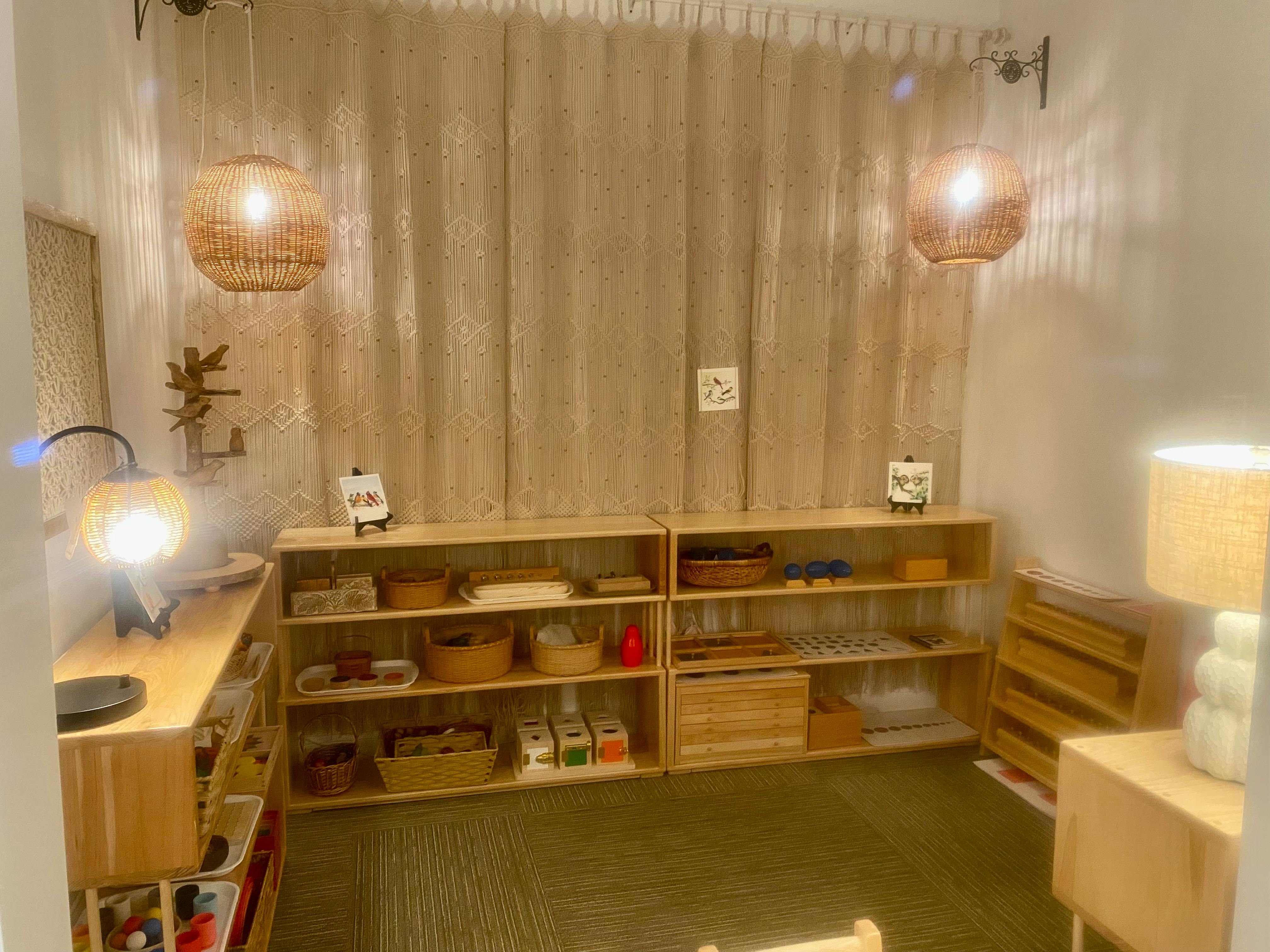 Room with wooden shelves filled with various items, two hanging lights